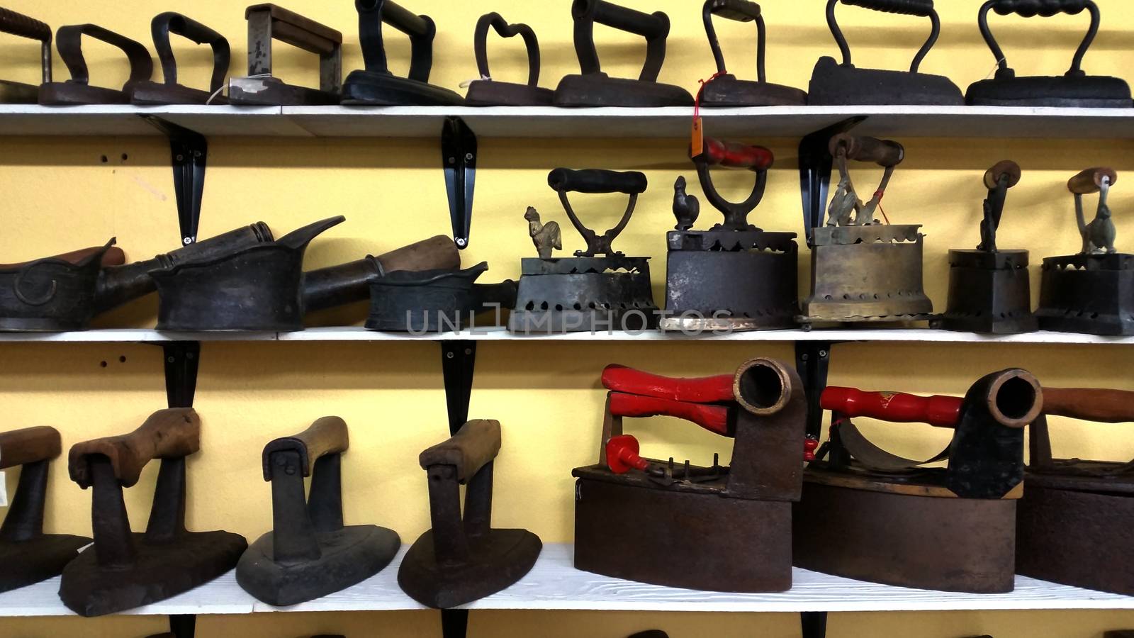 Collection of vintage laundry iron arrange on the shelve