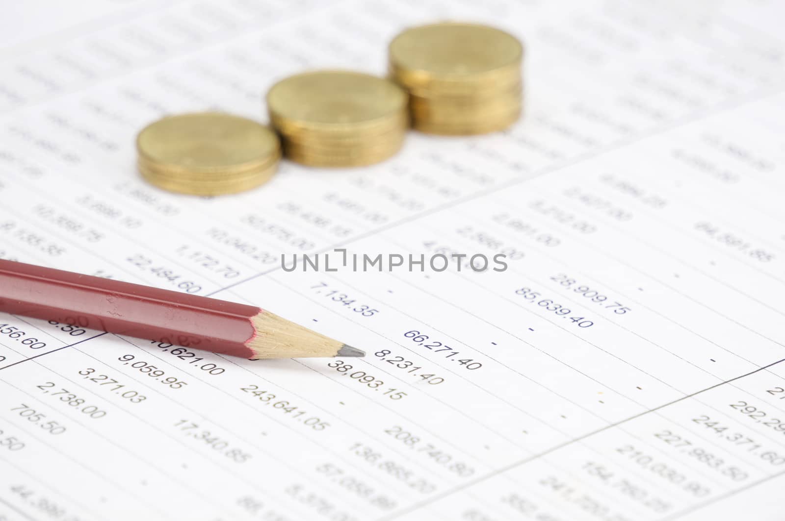 Close up brown pencil with blur step pile of gold coins place on finance account as background.