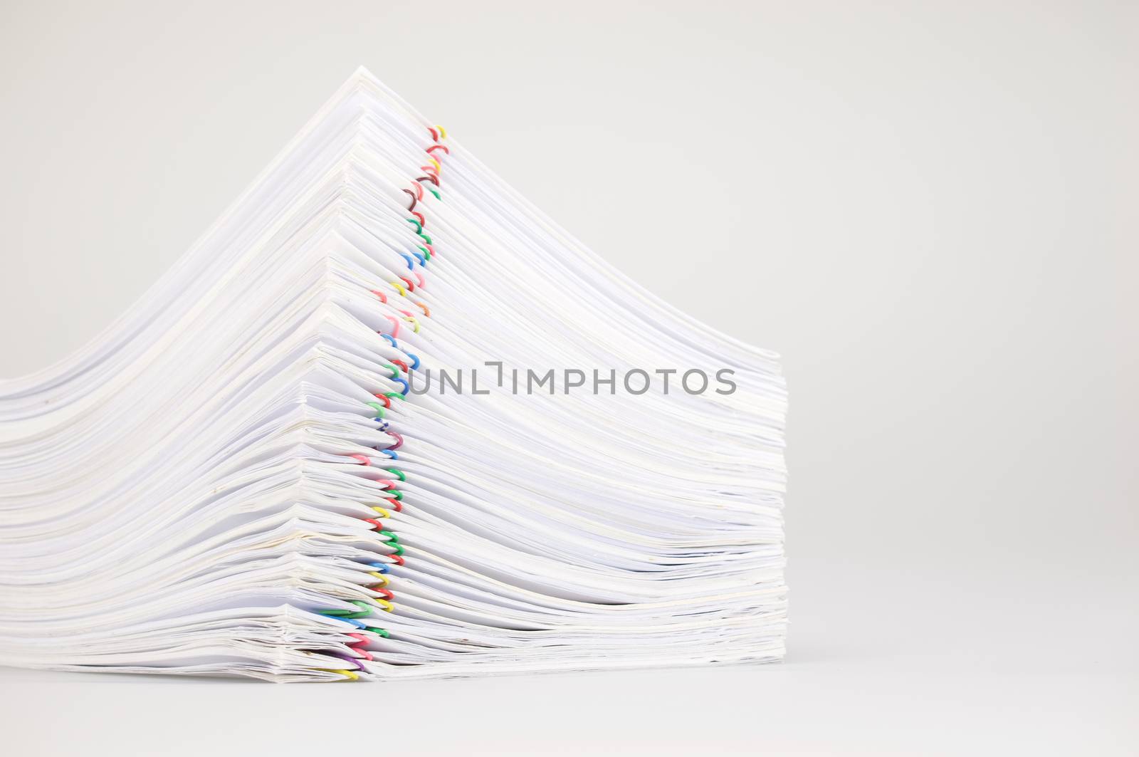 Pile overload paperwork with colorful paperclip place on white background by eaglesky