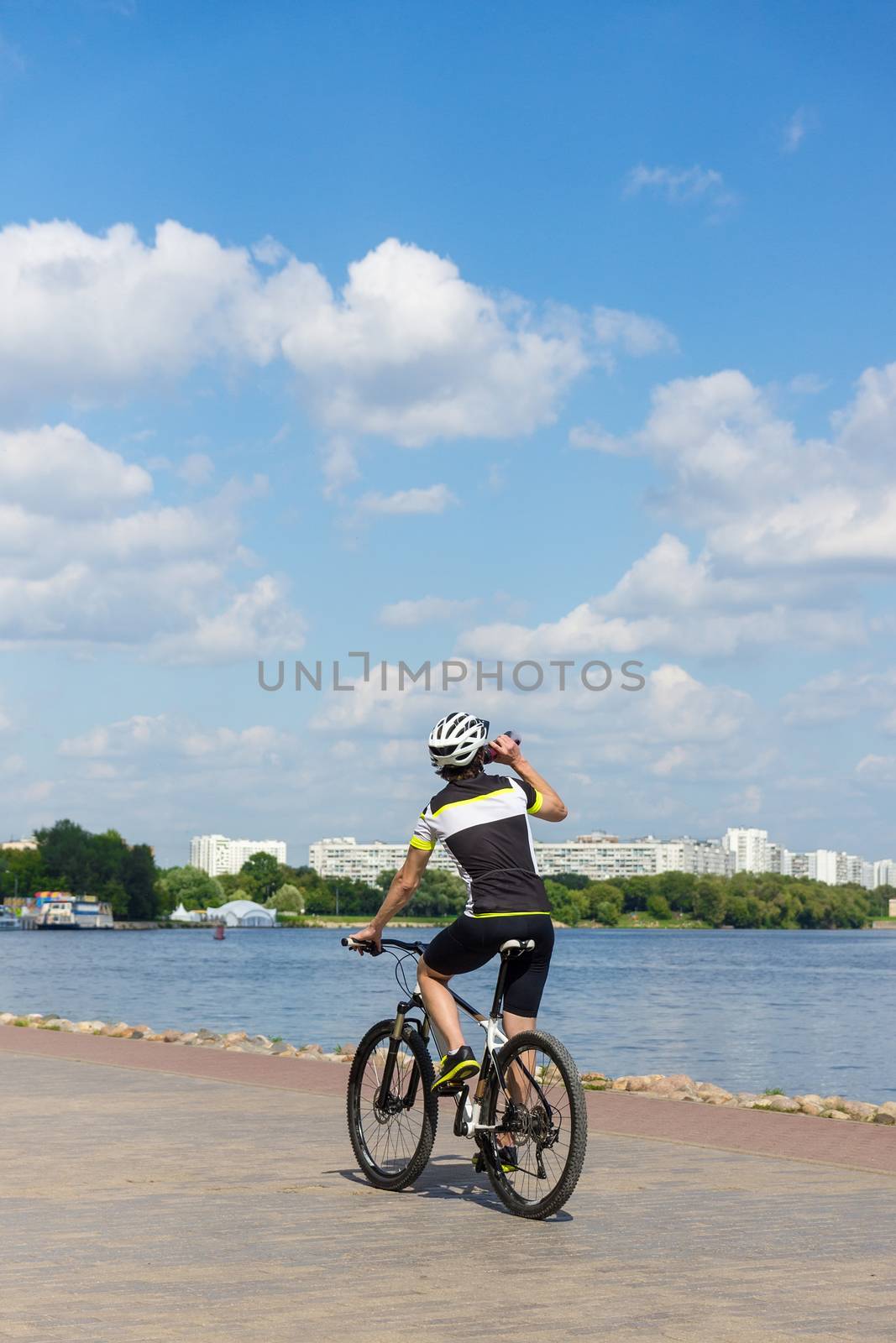 The photo depicts a cyclist racing along the river