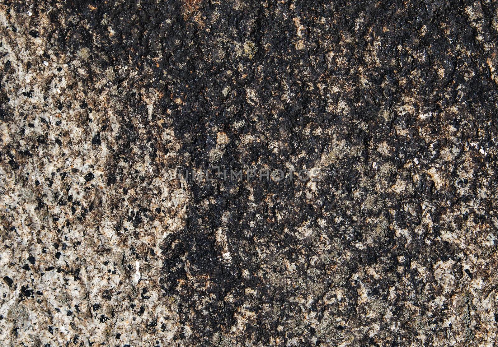 Close-up of an old granite stone pattern with black colorization.