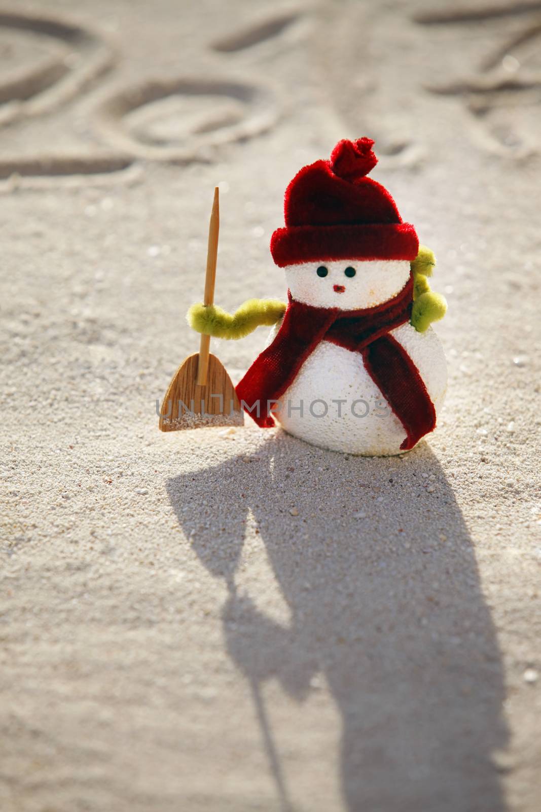 Toy snowman on the sand and figures 2017