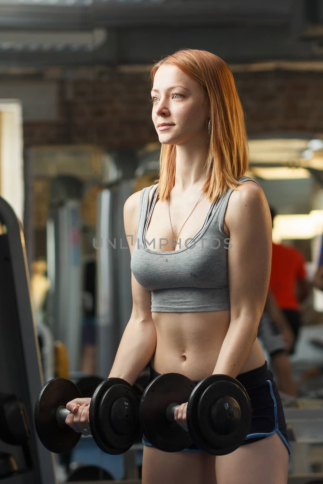 Concept: sport, healthy lifestyle. Young strong girl do exercises with dumbbells