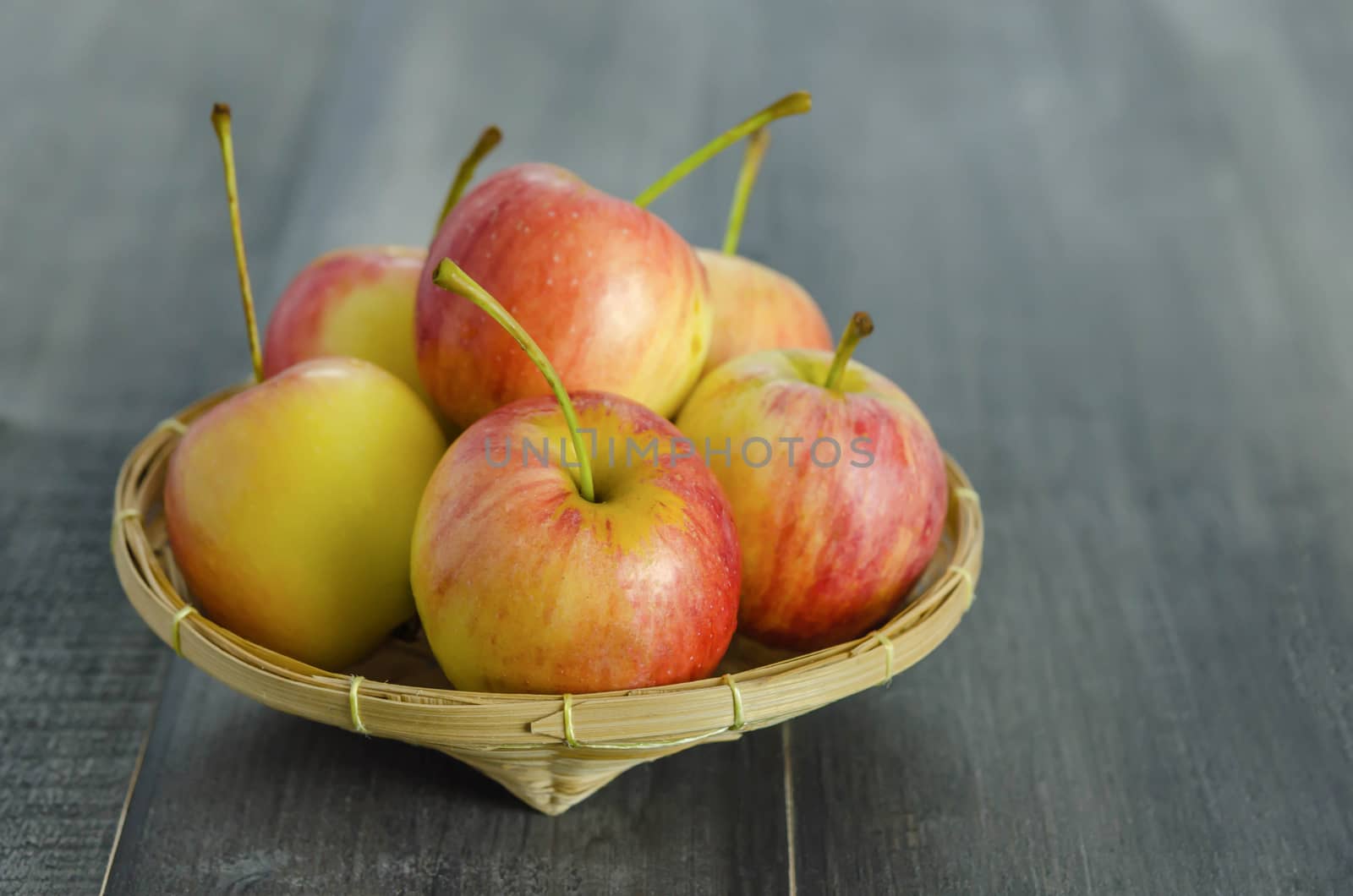 Red and yellow apple  with bamboo basket , organic fresh fruit on white  wooden background