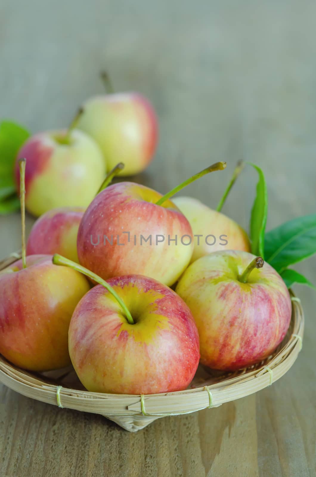 Red and yellow apple  with bamboo basket , organic fresh fruit on white  wooden background