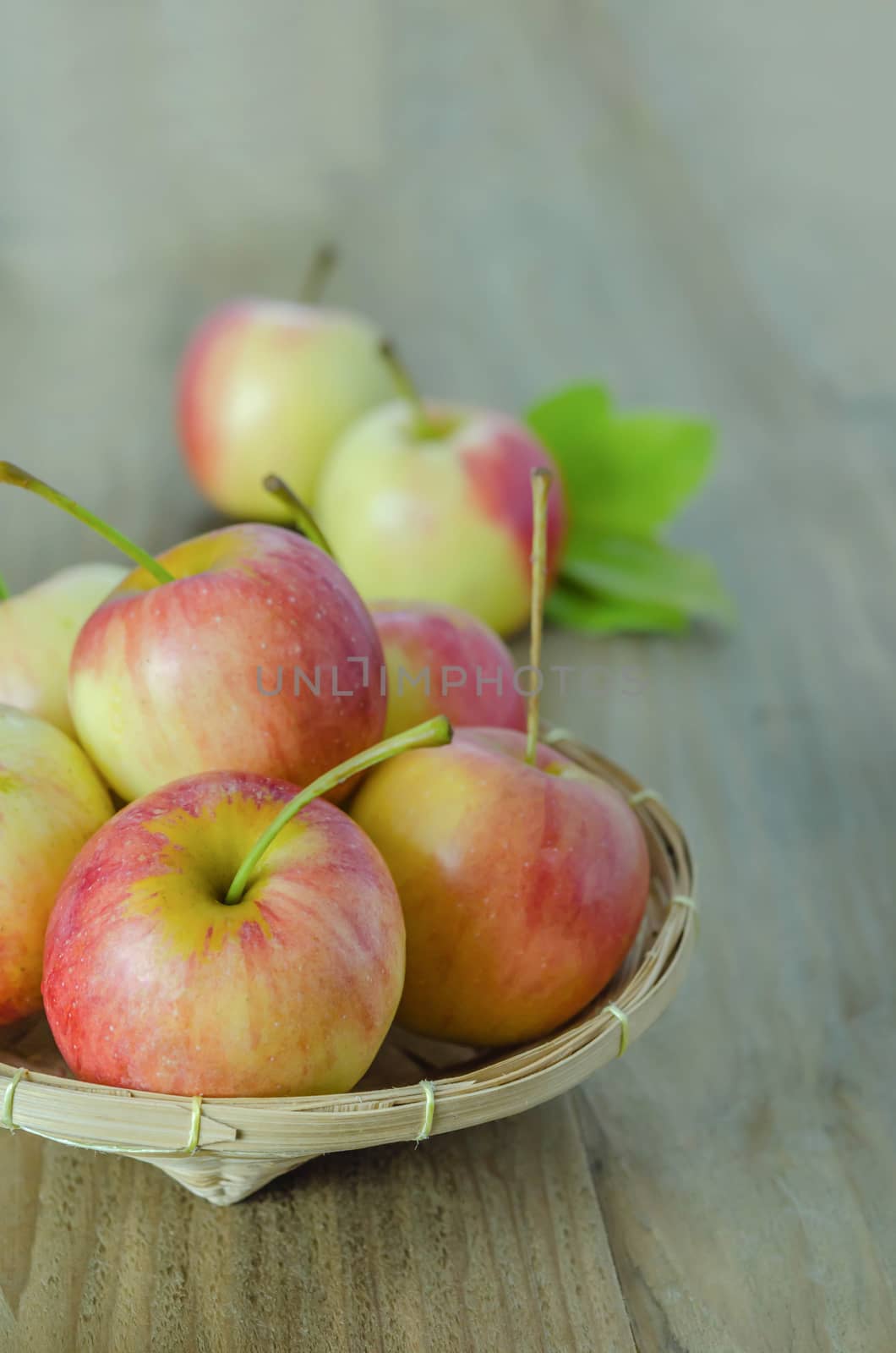 Red and yellow apple  with bamboo basket , organic fresh fruit on white  wooden background