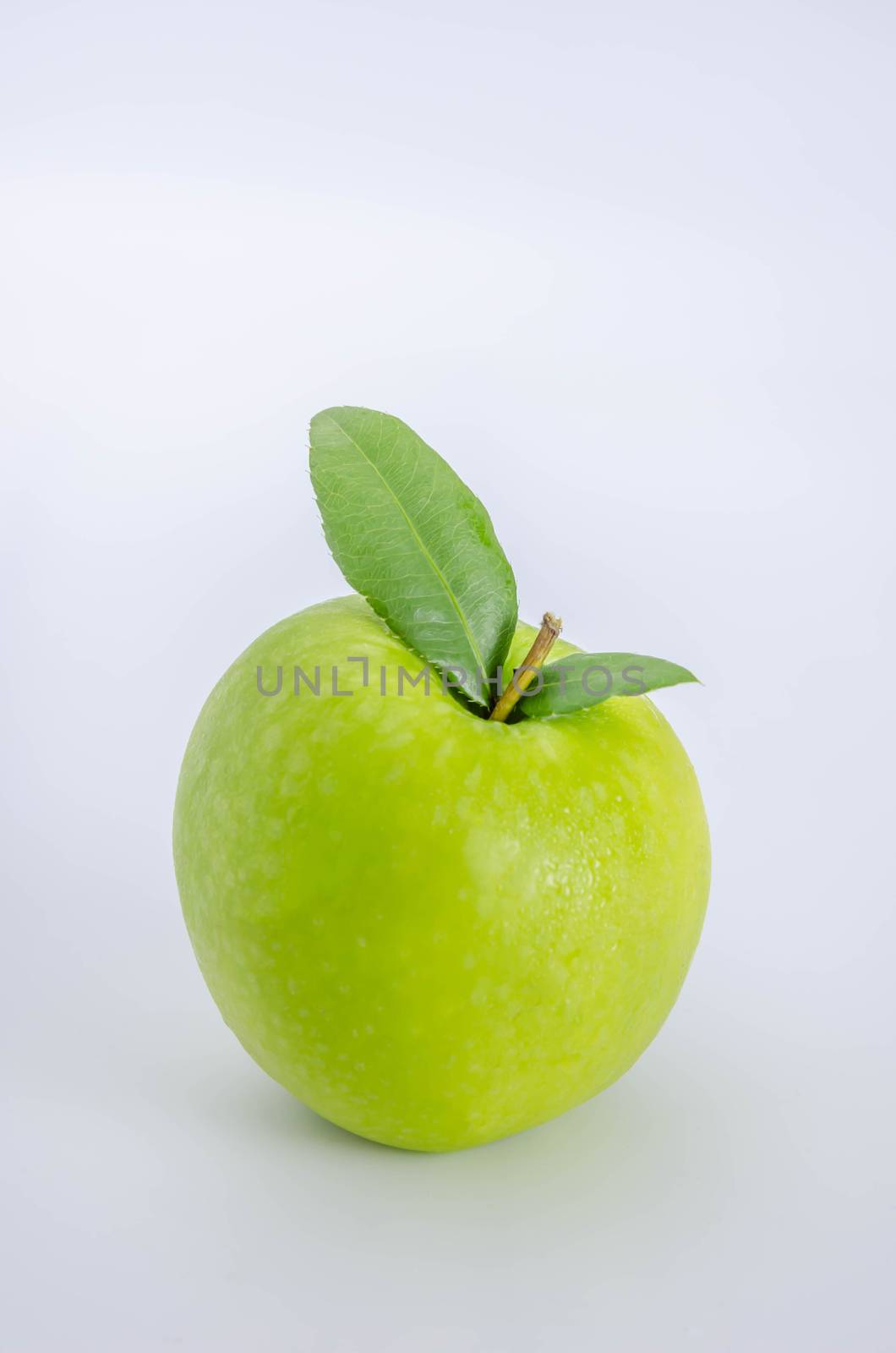 Ripe green apple with leaf  on a white background
