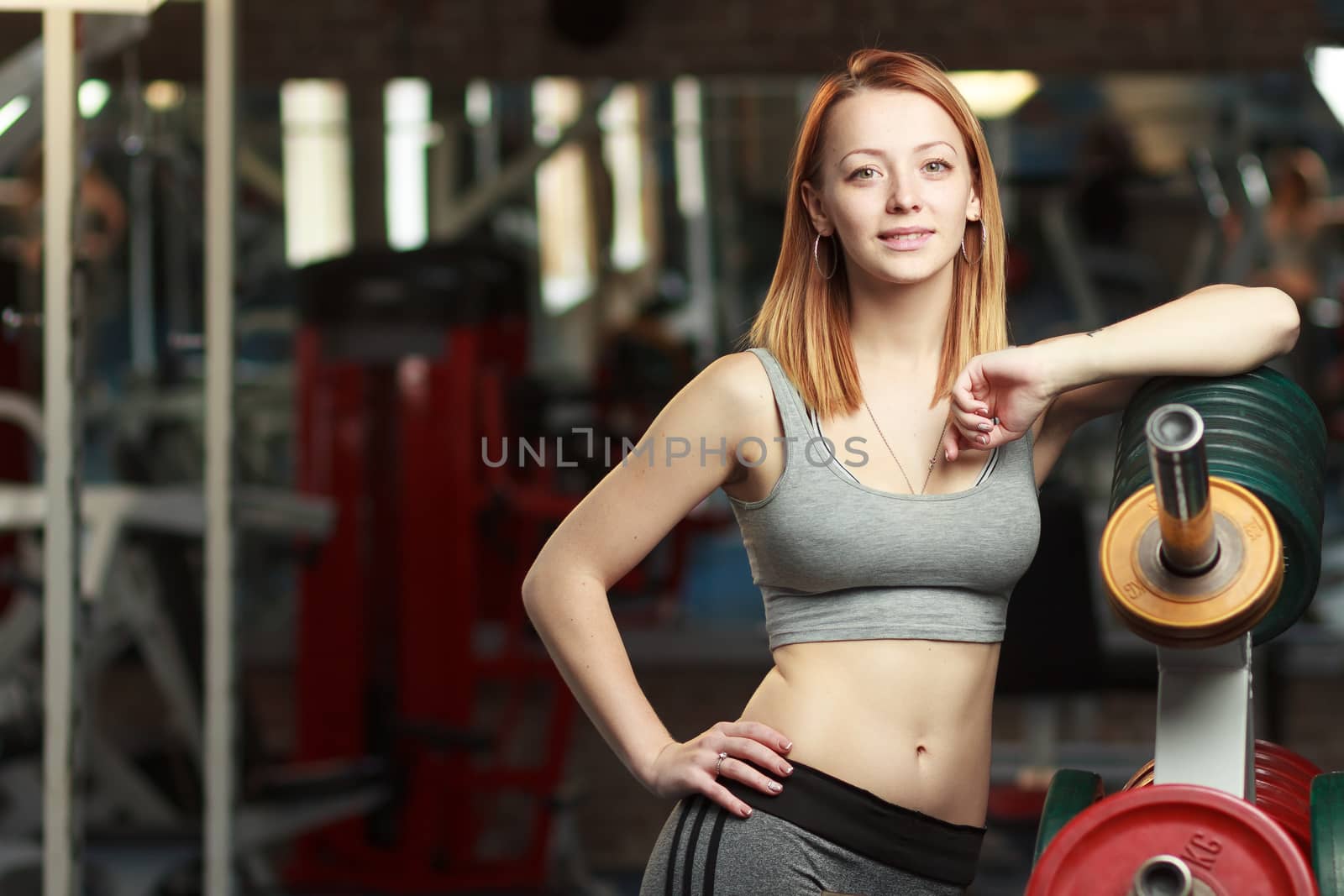 Concept: sport, healthy lifestyle. Young strong girl take breather in gym