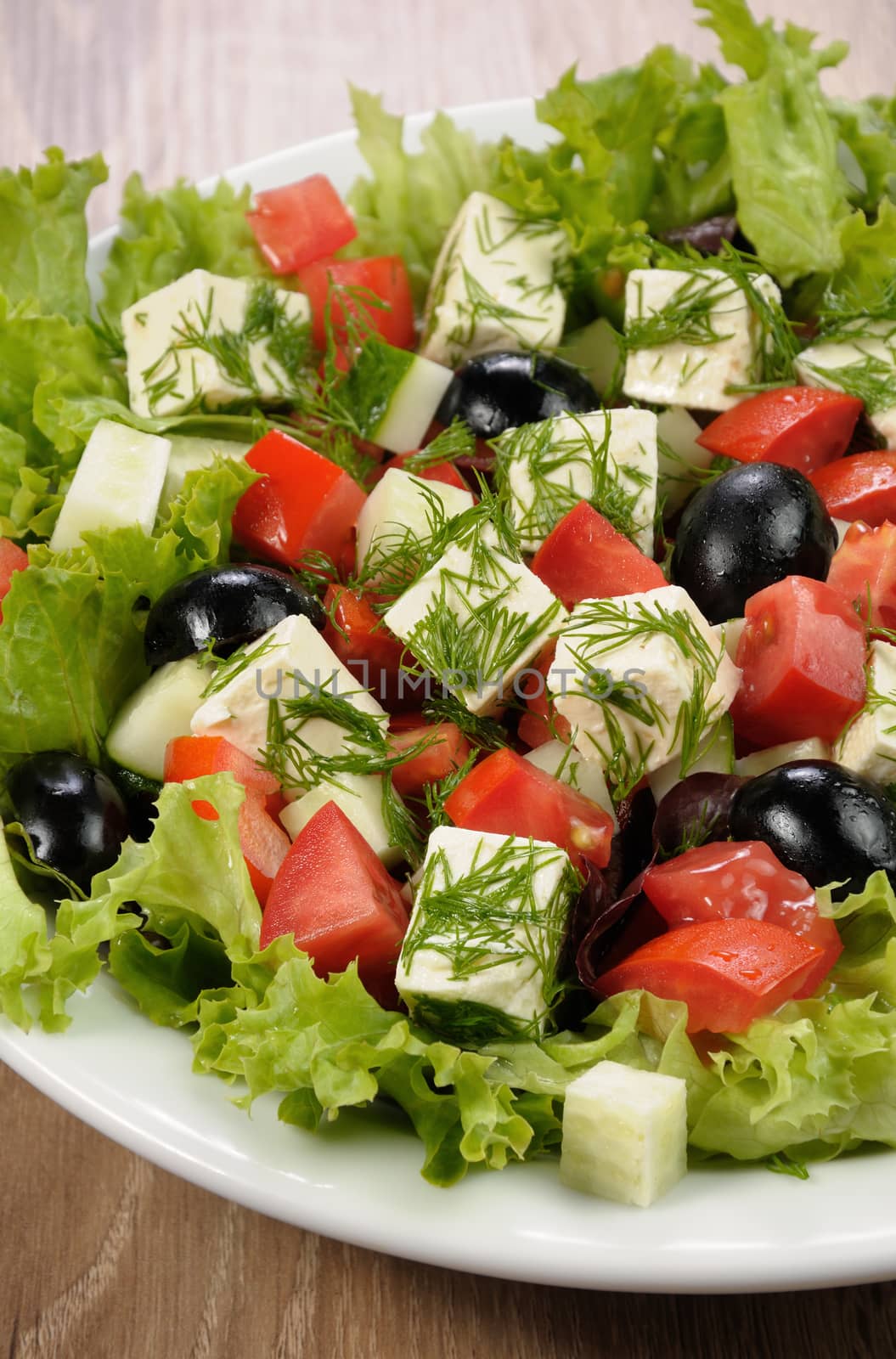 Salad of lettuce with diced olives, tomato, cucumber, feta at dill
