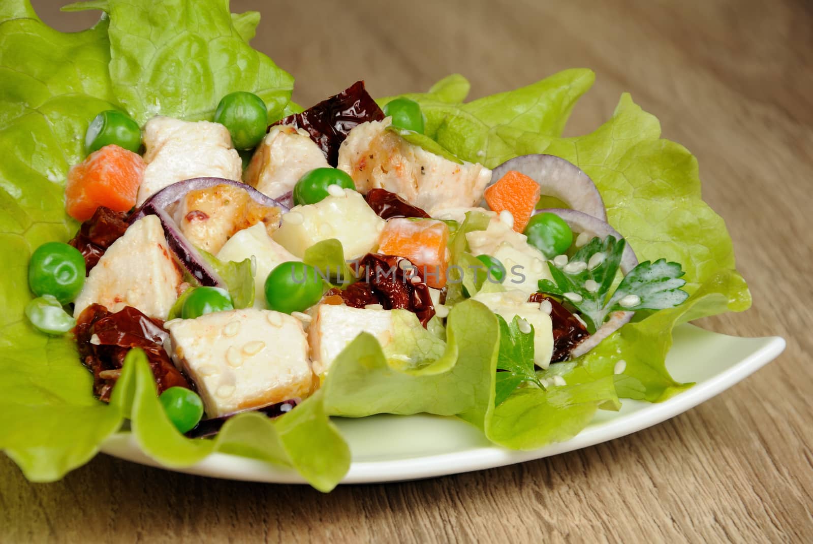 A portion of salad in milk sauce with sesame seeds in lettuce leaves