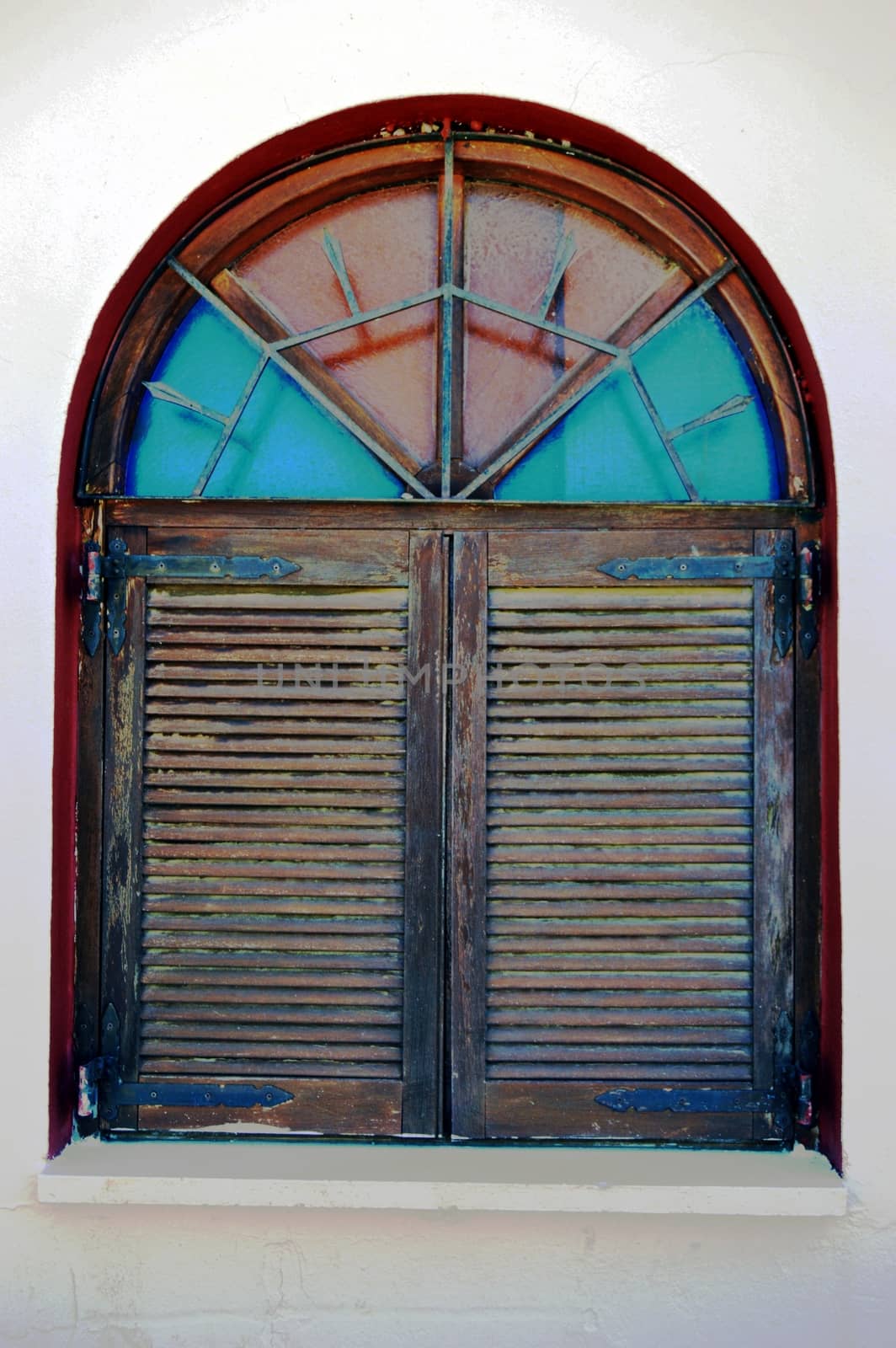 A wooden window with shutters and stained-glass windows.