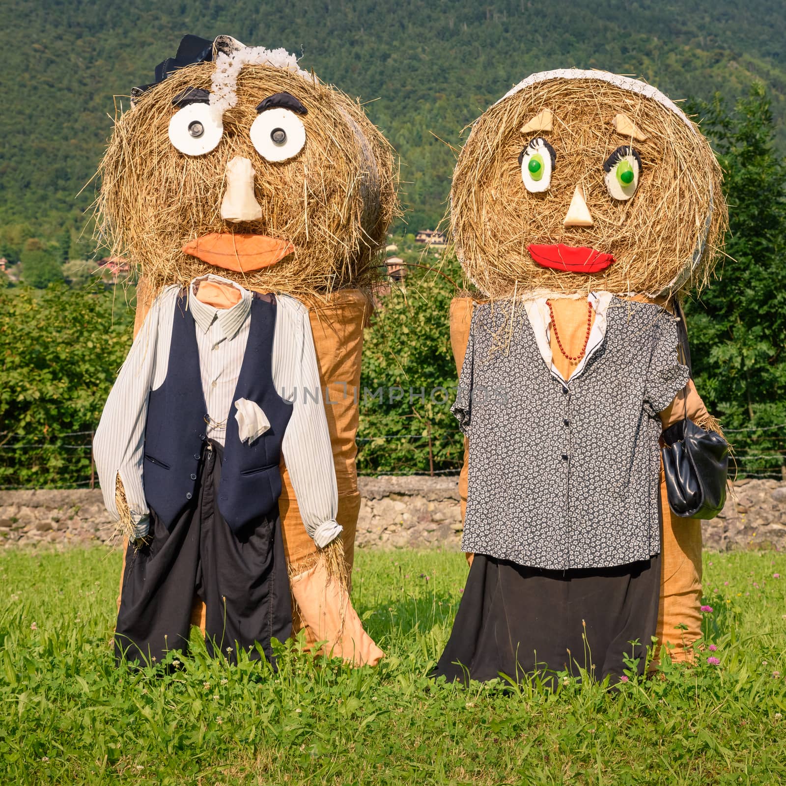 Lovely farmers Couple Puppets(straw dolls) made out of Hay Bale with typical peasant clothes in europe autumn,square photo.