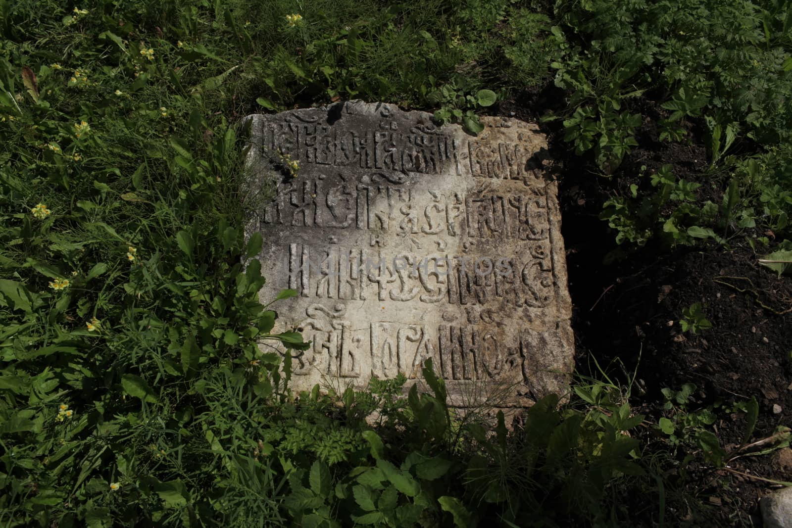 fragment of ancient gravestone inscription in the ancient language close to