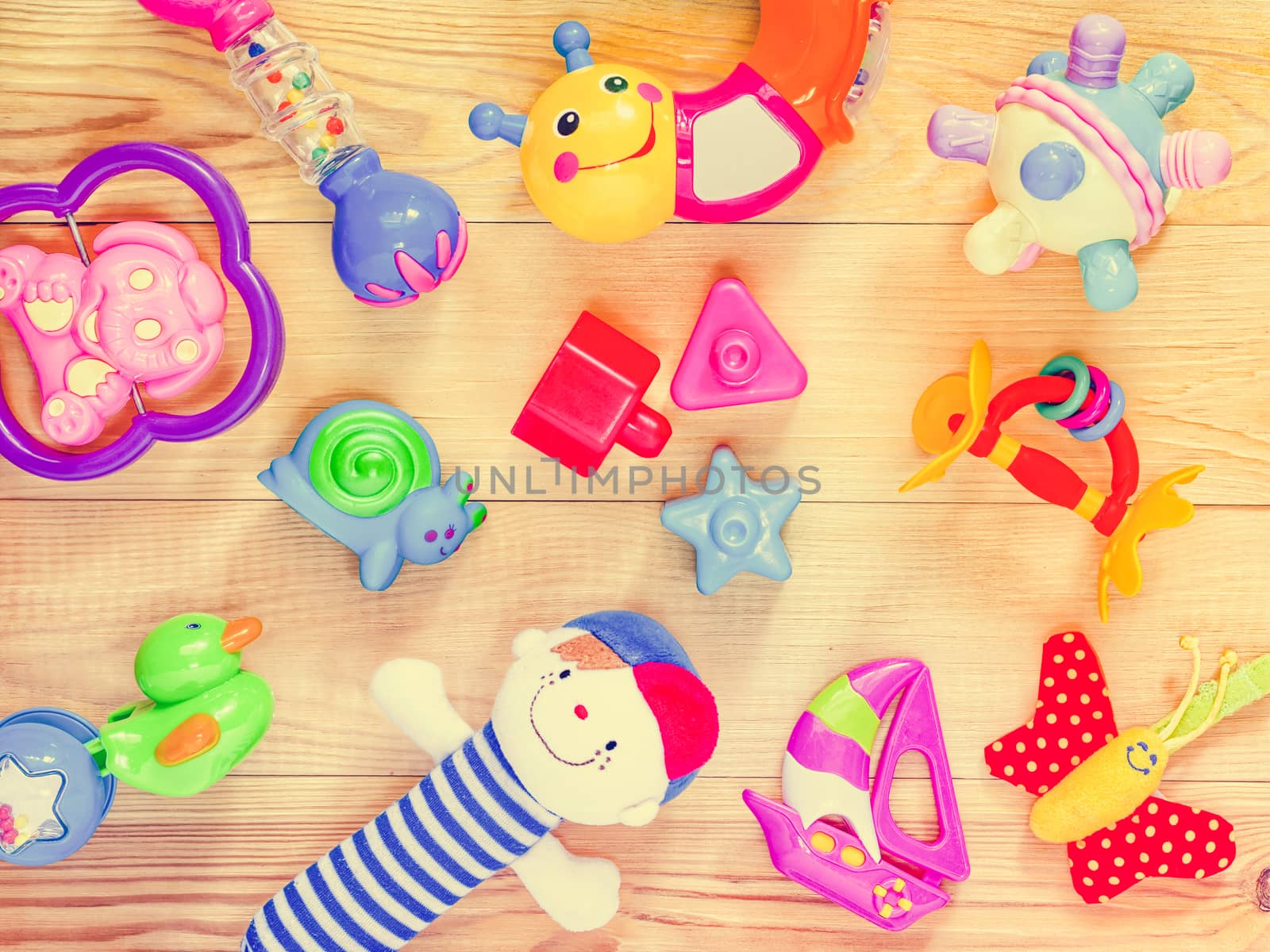 top view or flat lay on colorful toys on light wooden background. Retro vintage filtered