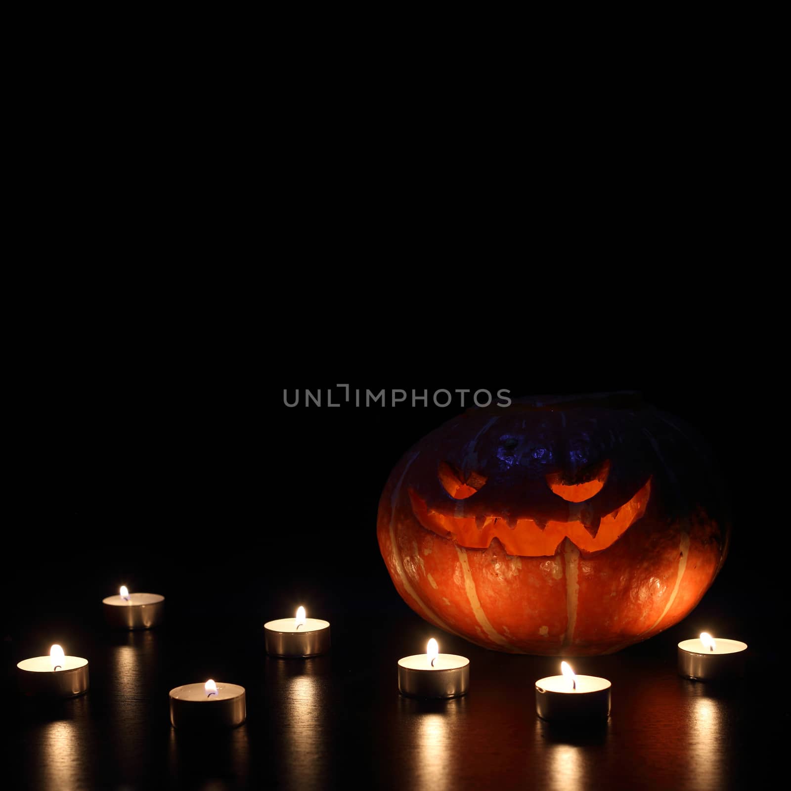 Illuminated cute halloween pumpkin isolated on black background