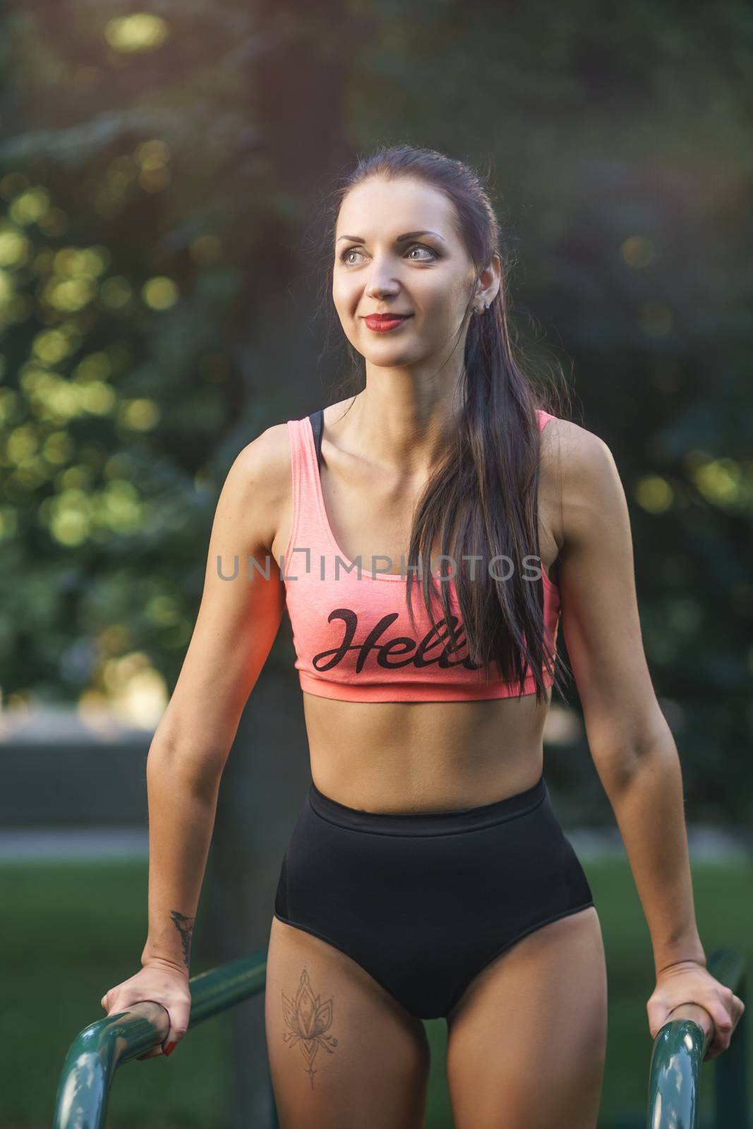 Concept: sport, healthy lifestyle. Young strong girl do exercises during street workout