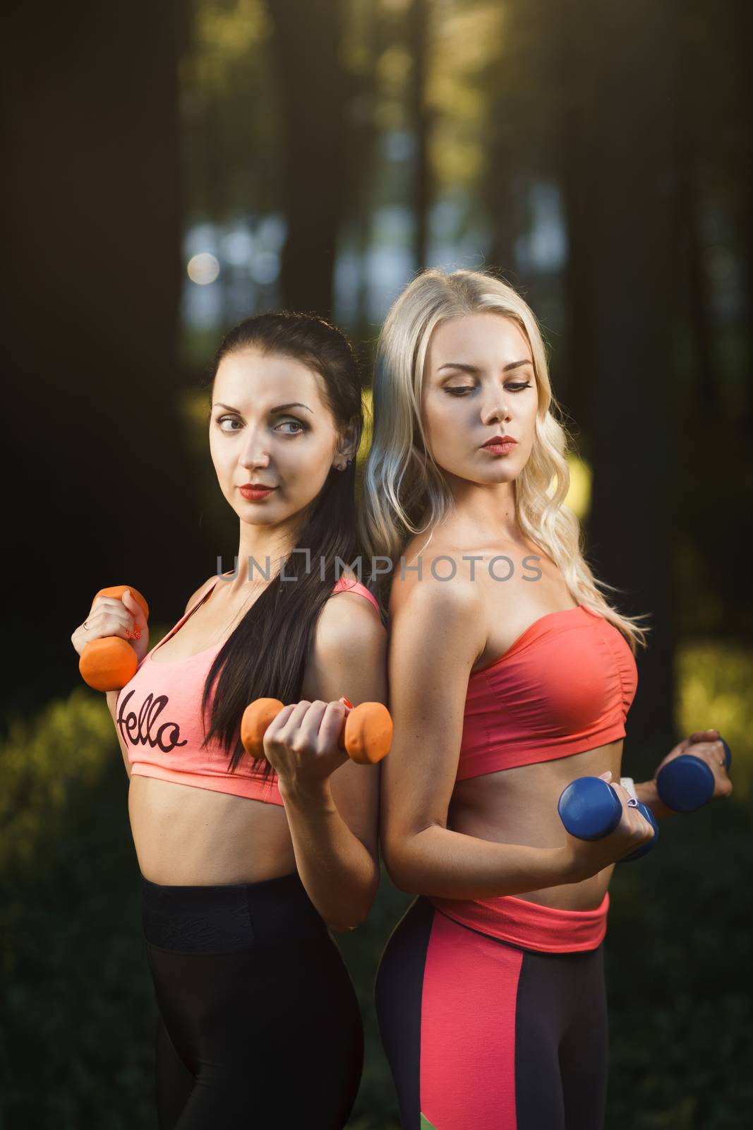 Young strong girls do exercises during street workout by mrakor