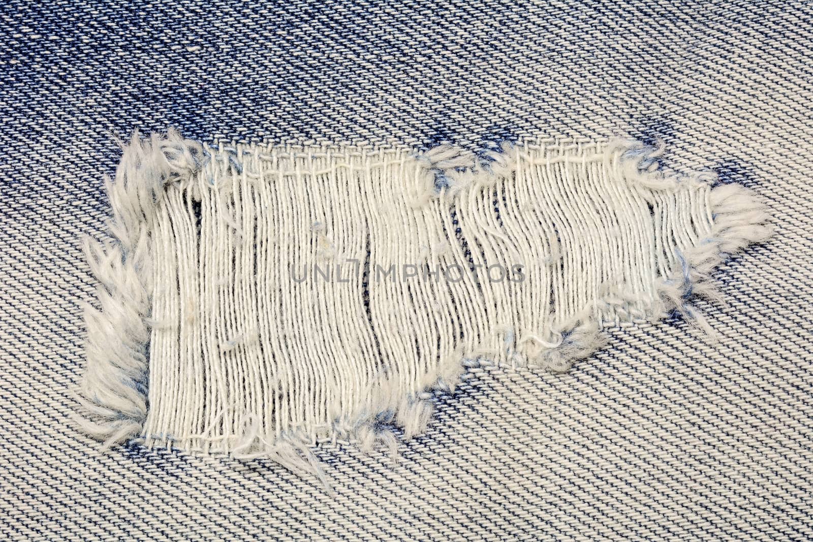  blue jean texture with a hole and threads showing by ipuwadol