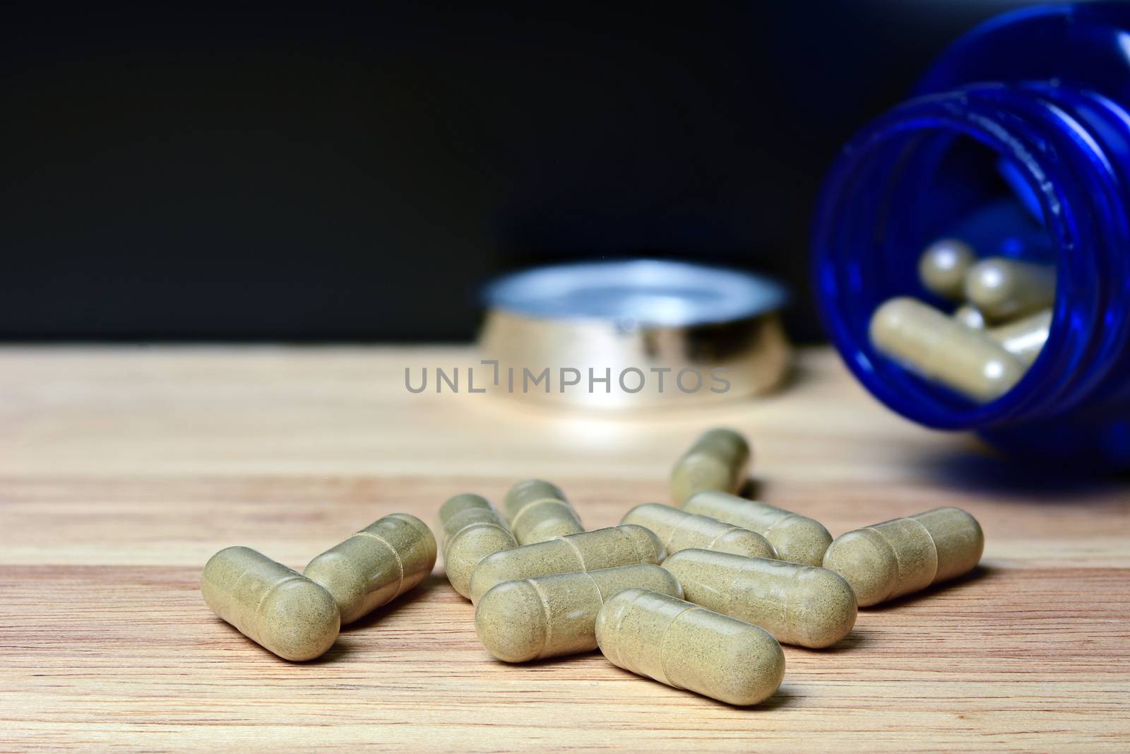 Herbal medicine in capsule on table