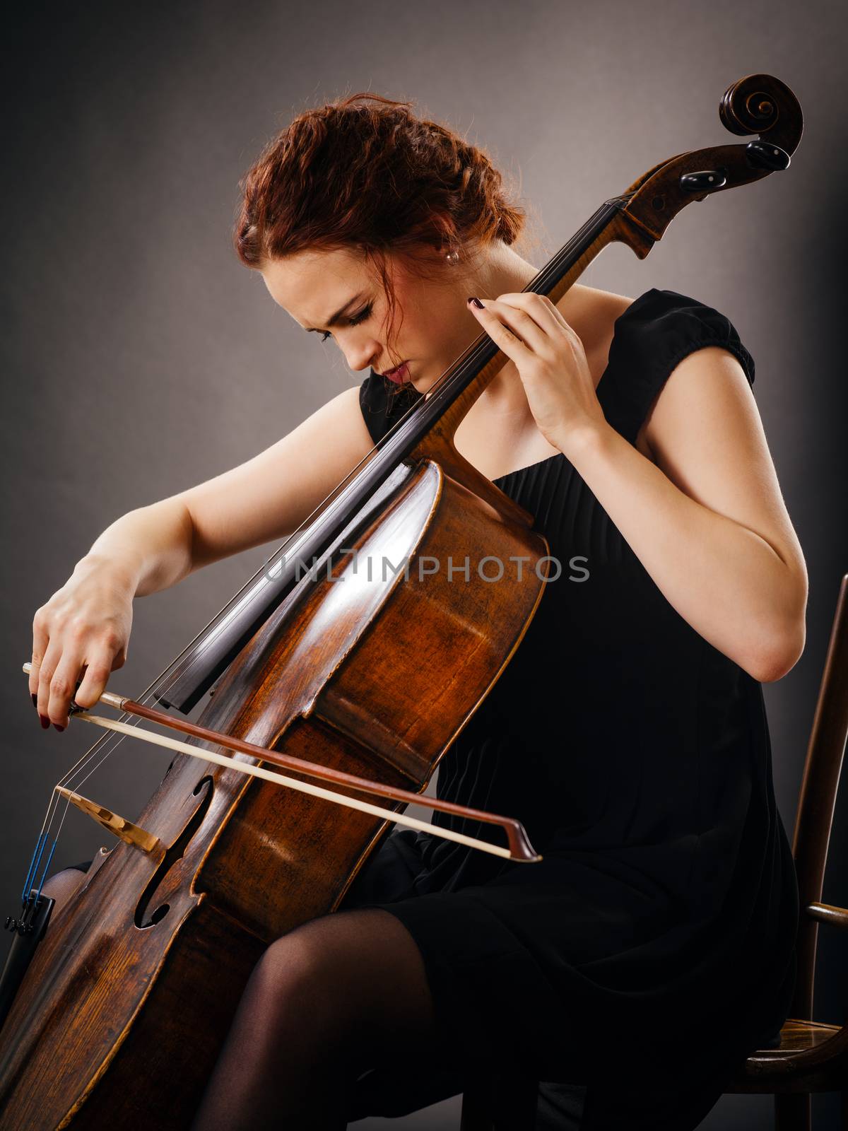Photo of a beautiful woman concentrating on her cello playing.