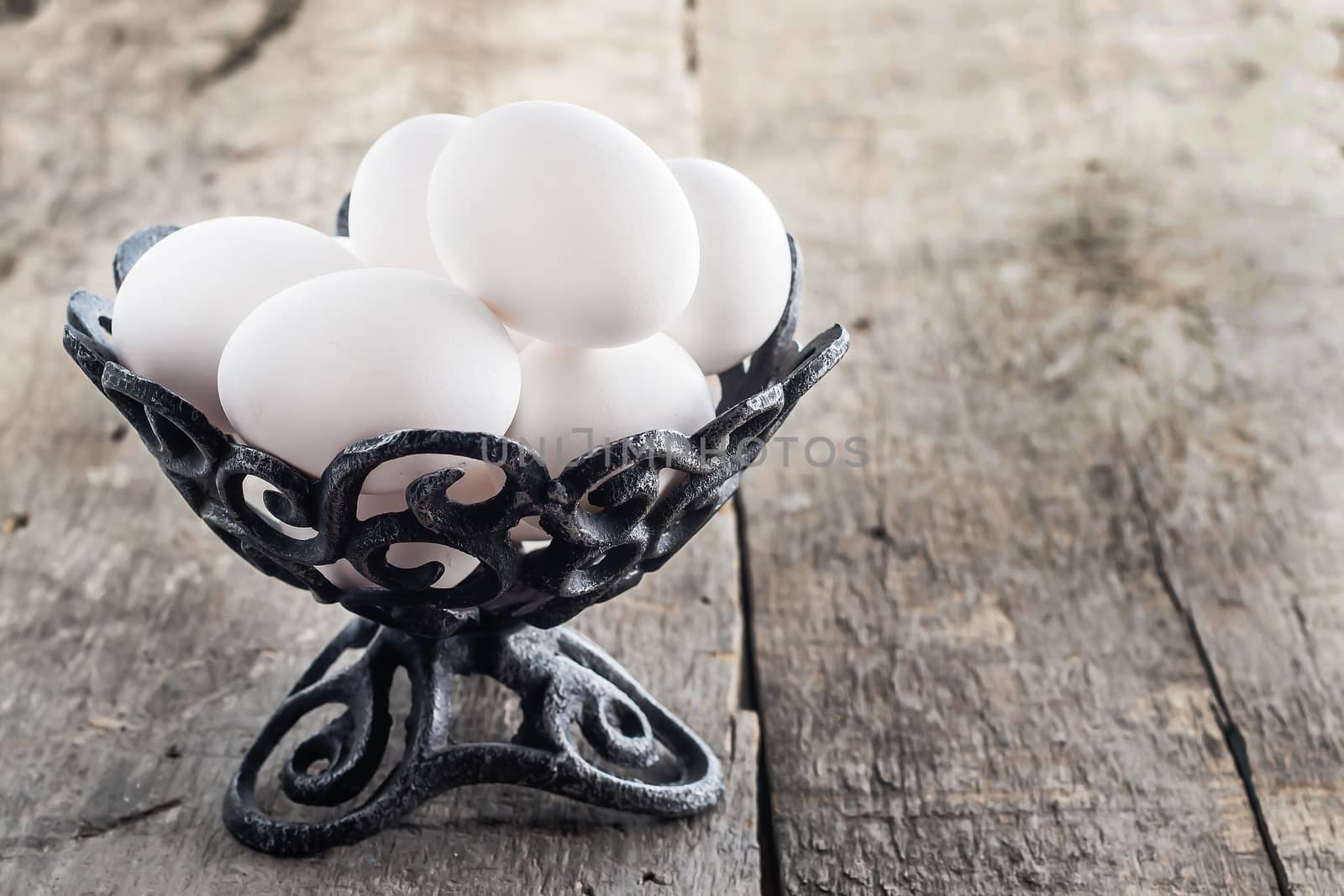 raw chicken white eggs in an iron antique vase.