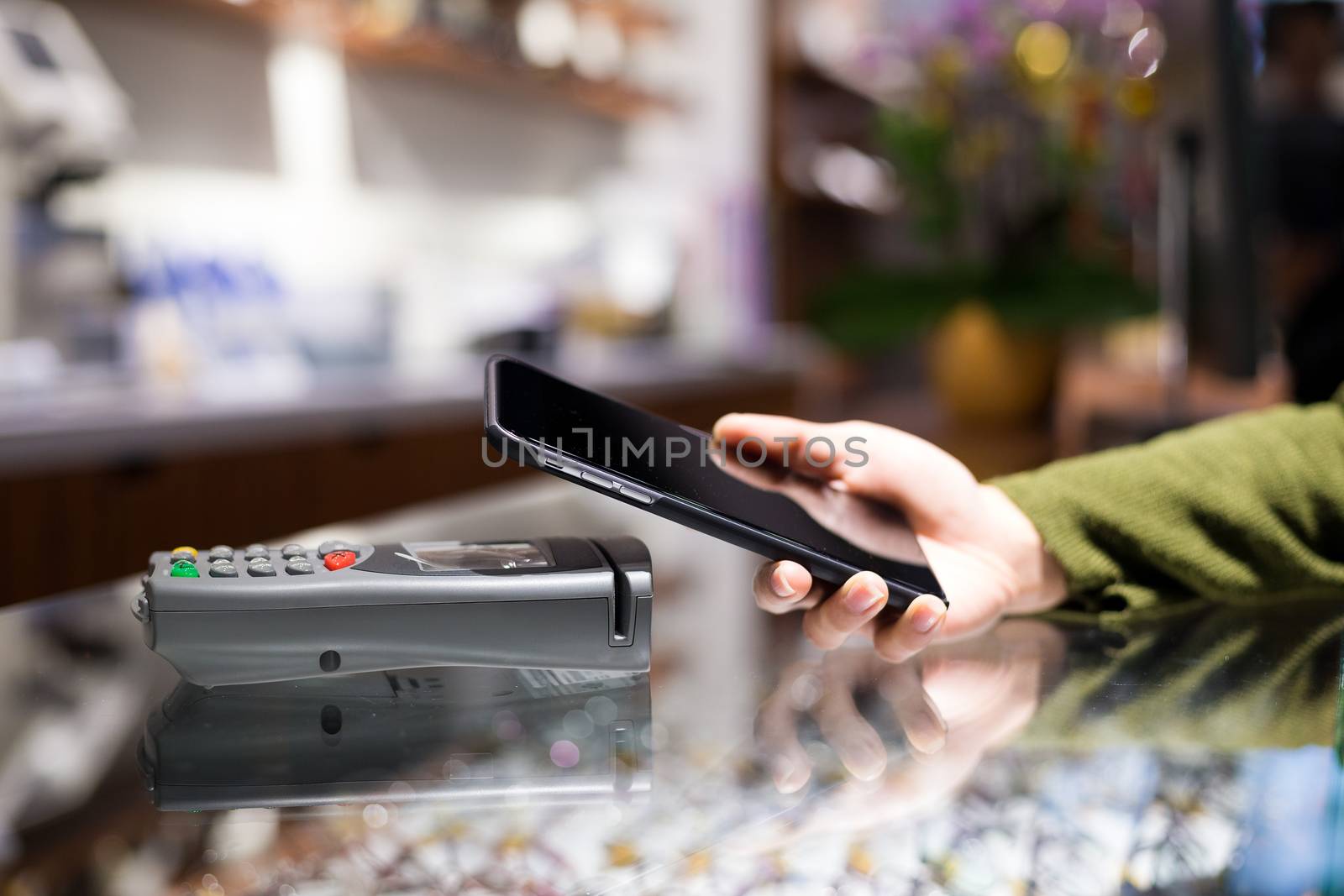 Woman paying on mobile phone by NFC