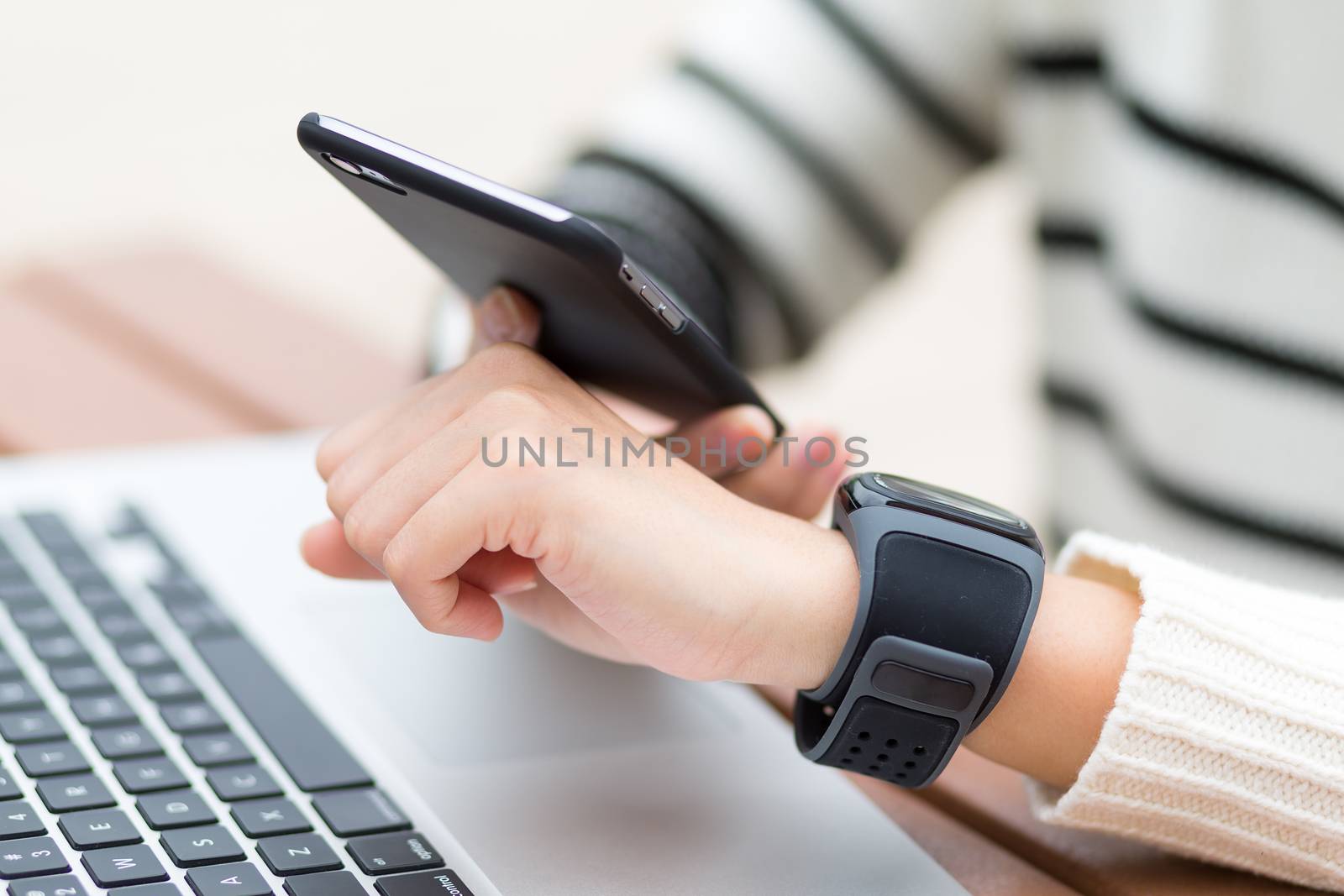 Woman connecting smart watch and cellphone by leungchopan