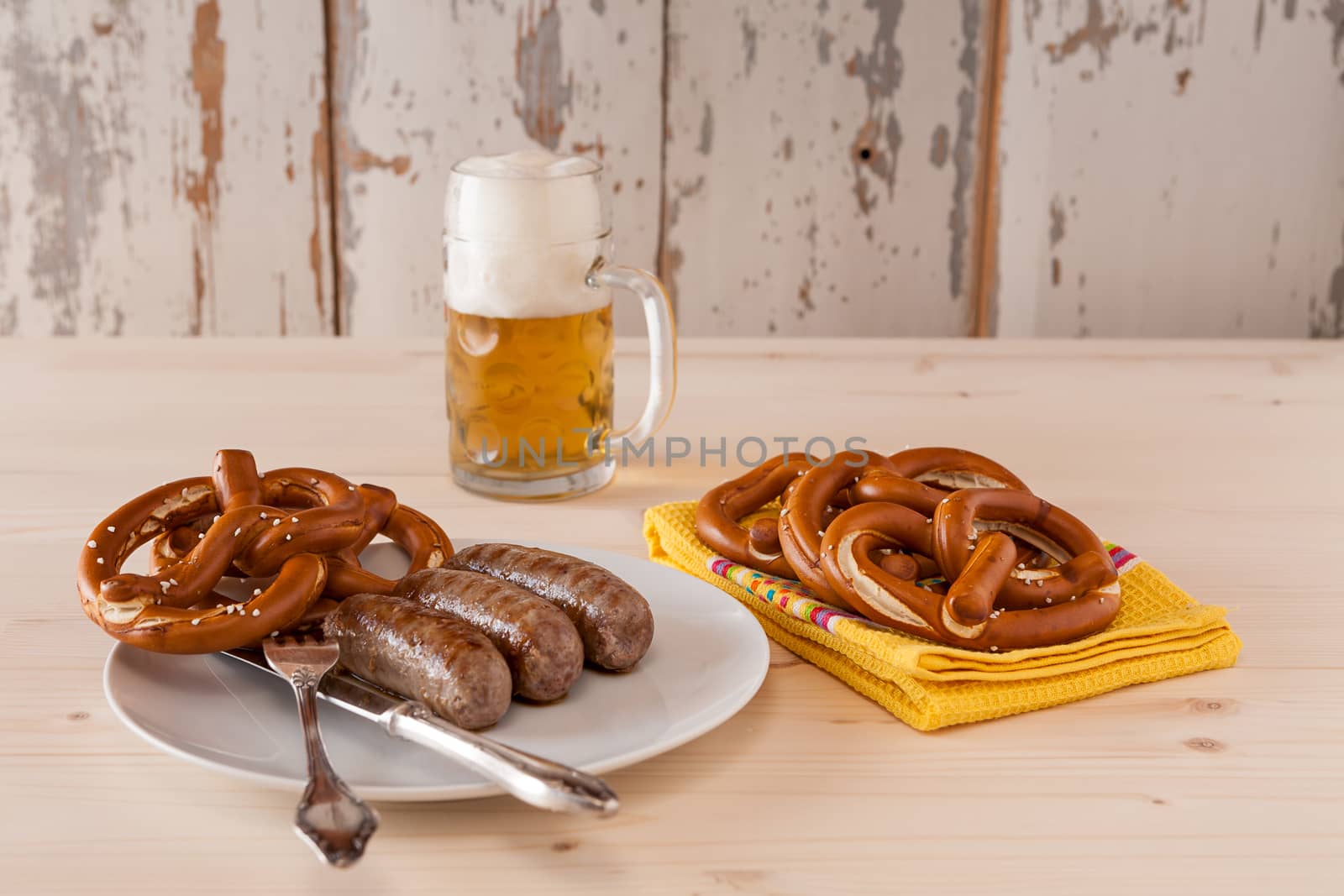 Bavarian cooked sausage and pretzel on a plate and beer