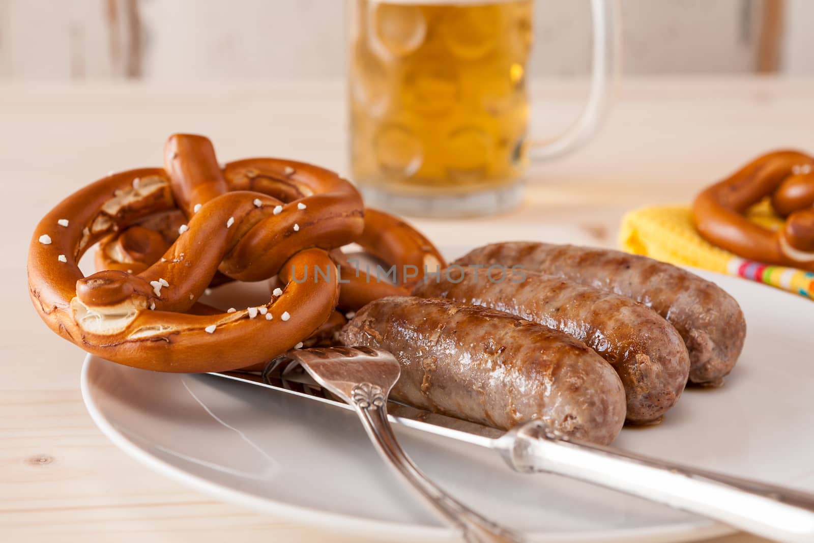 Closeup of bavarian cooked sausage and pretzel and a glass of beer