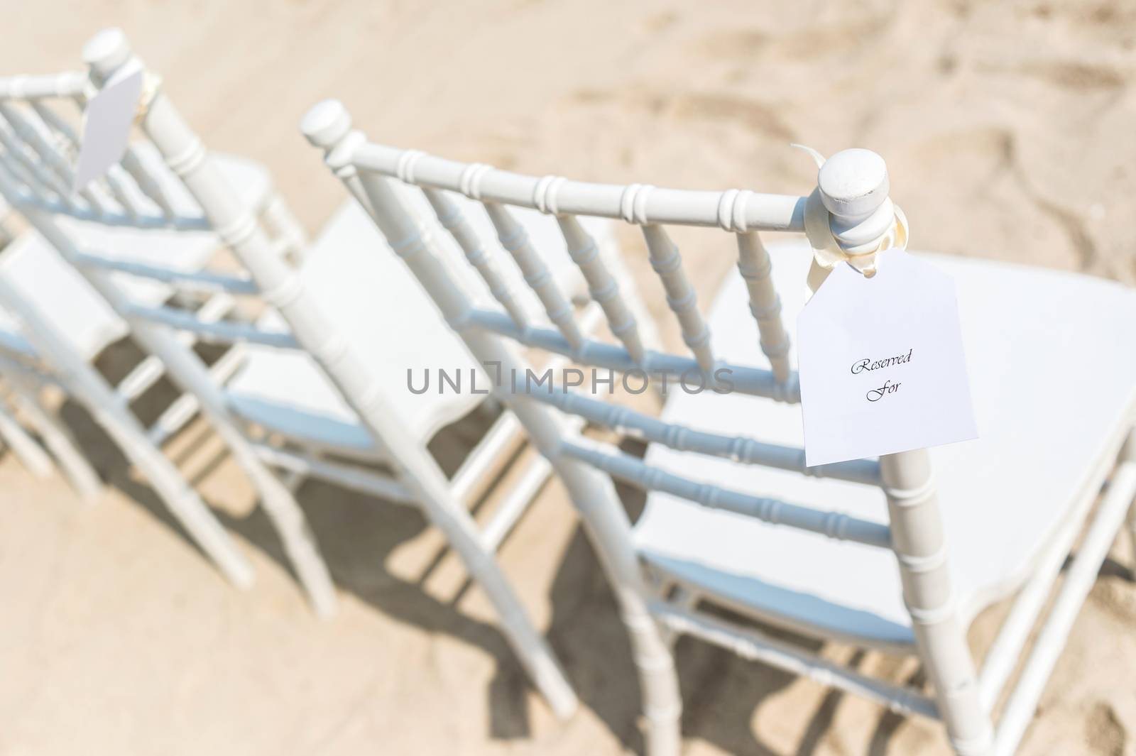 Chairs set up on white sand for beach wedding, reserved, selective focus