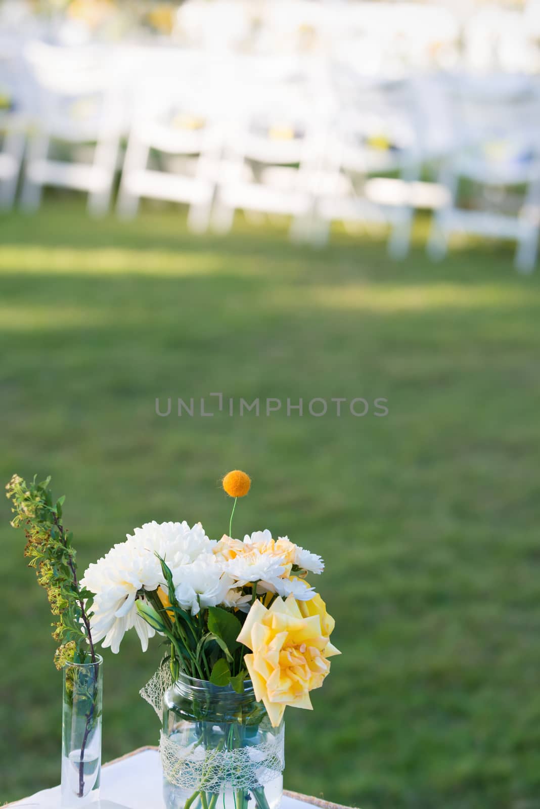 Elegance table set up white, green and yellow flowers theme, selective focus.