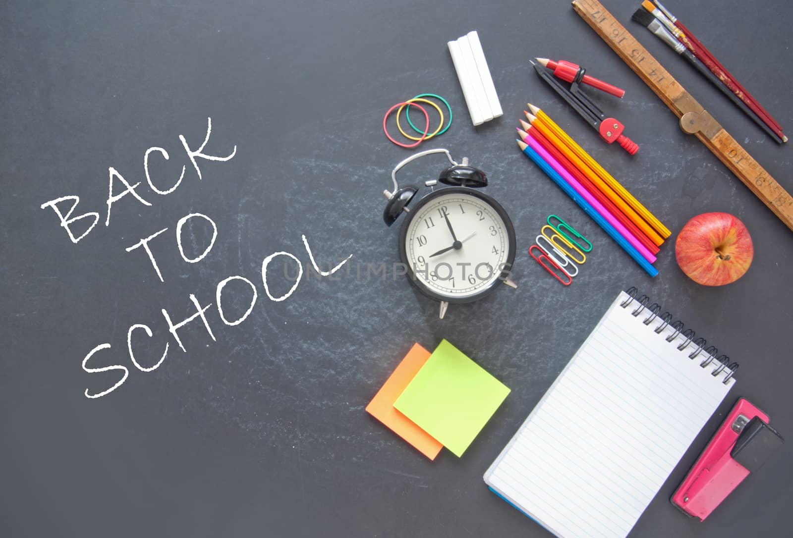 Back to school written on a chalkboad with stationery accessories