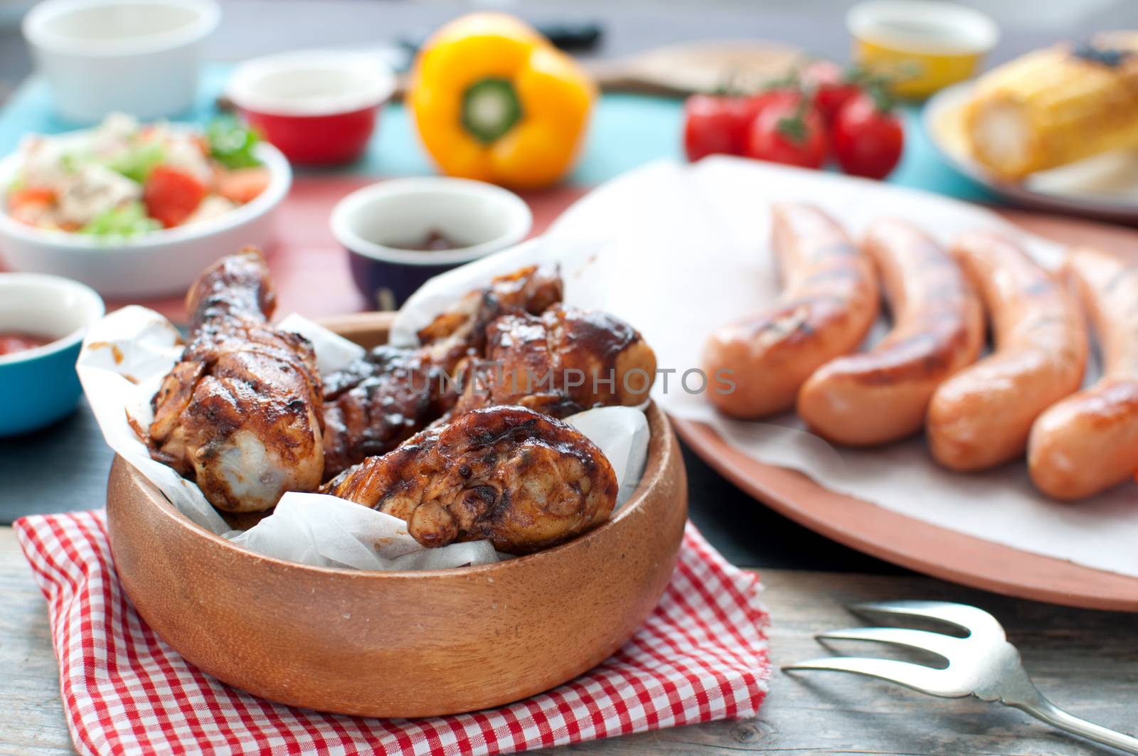 Meal consisting of grilled chicken and sausages with salad