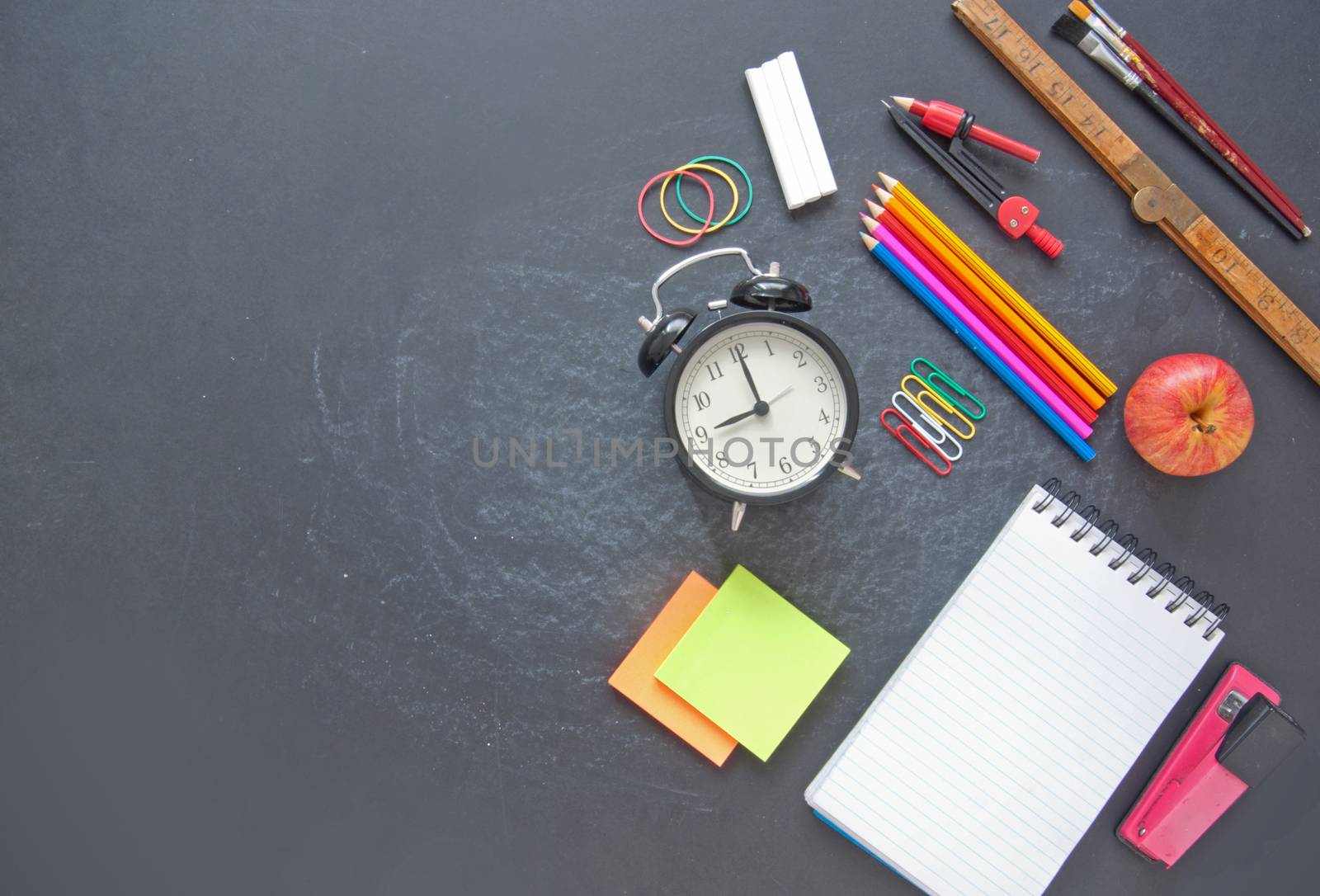 Stationery accessories on top of a chalkboard with space 