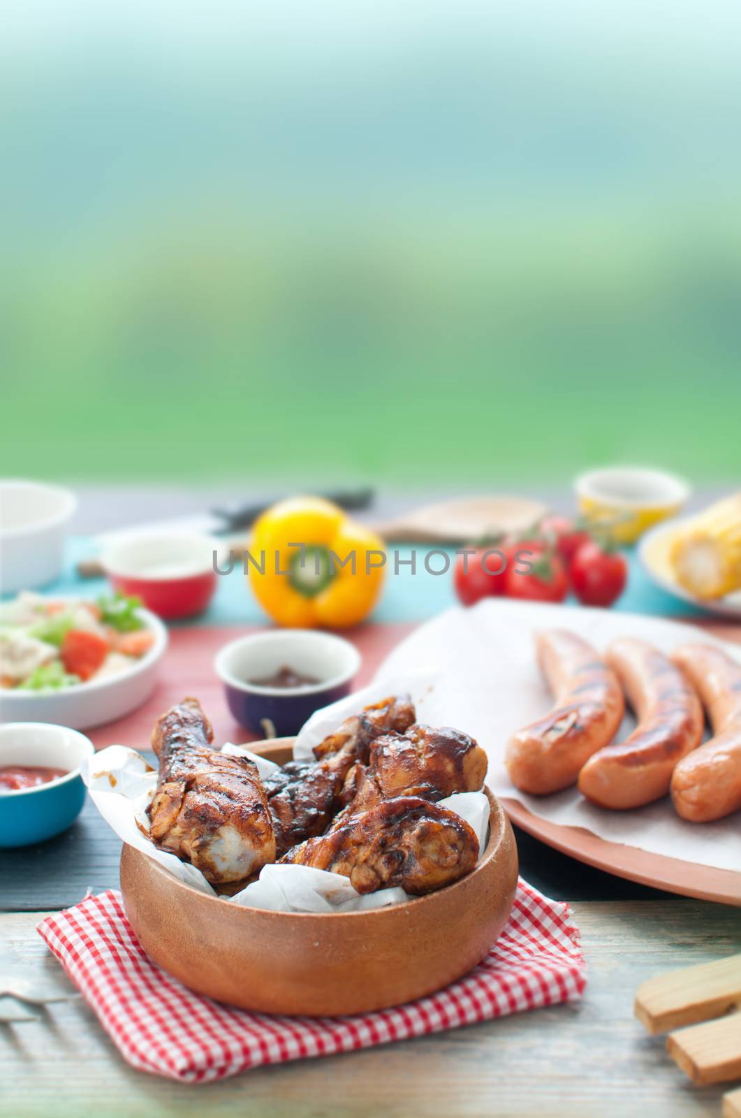 Selection of grilled barbecue meat including chicken and sausages with salad 