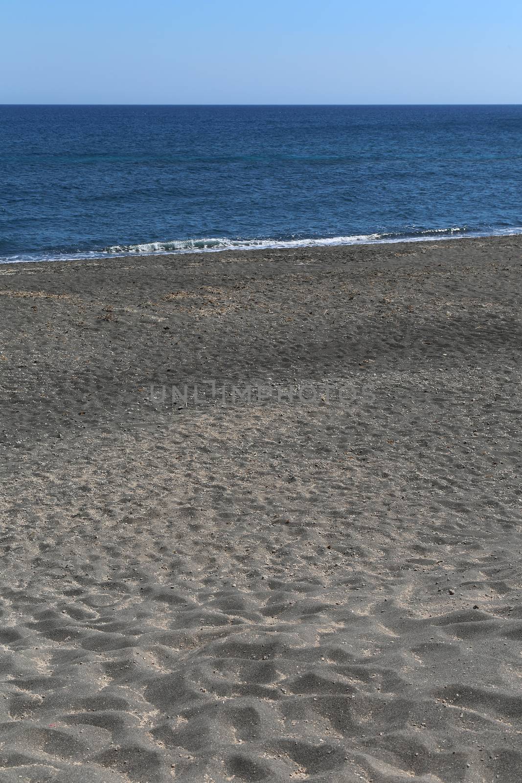 The Kamari beach with black volcanic stones at Santorini island, Greece