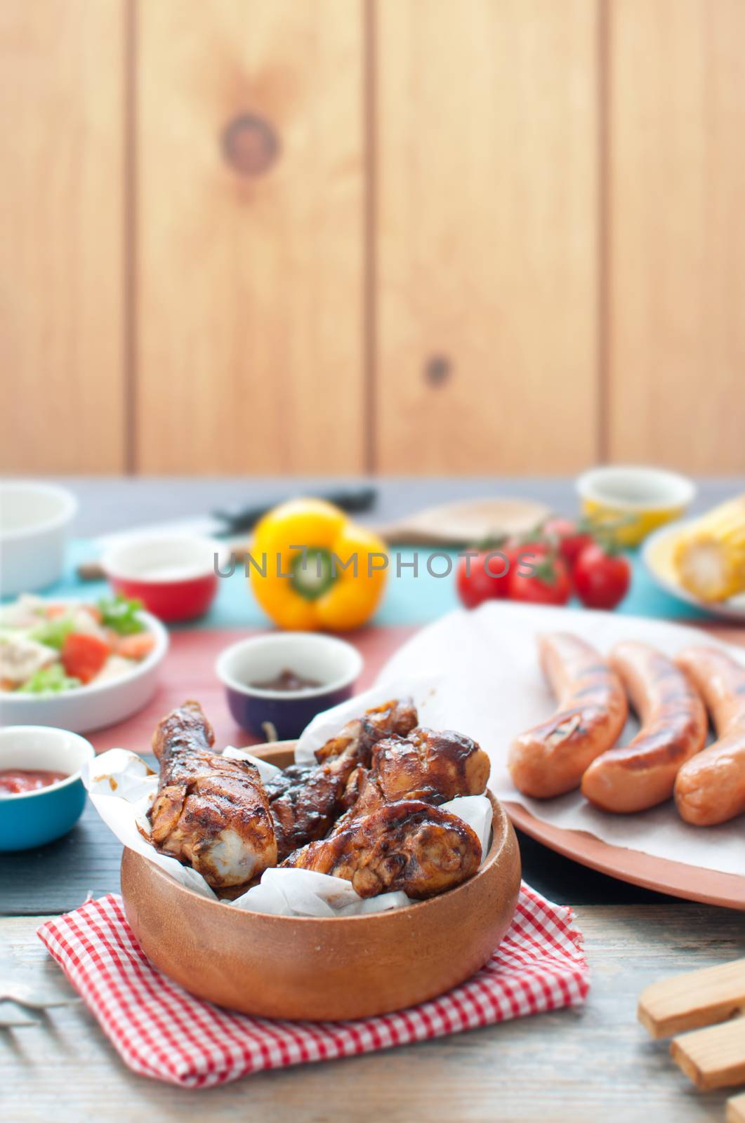Selection of grilled barbecue meat including chicken and sausages with salad 