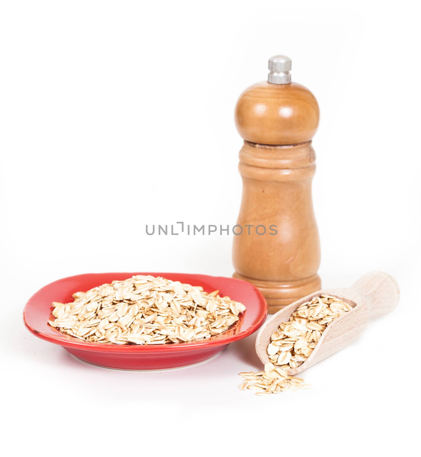 red dish  with oats flakes pile on white background.