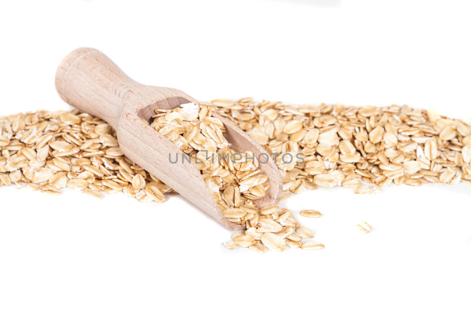 Oats flakes pile in wood spoon on white background