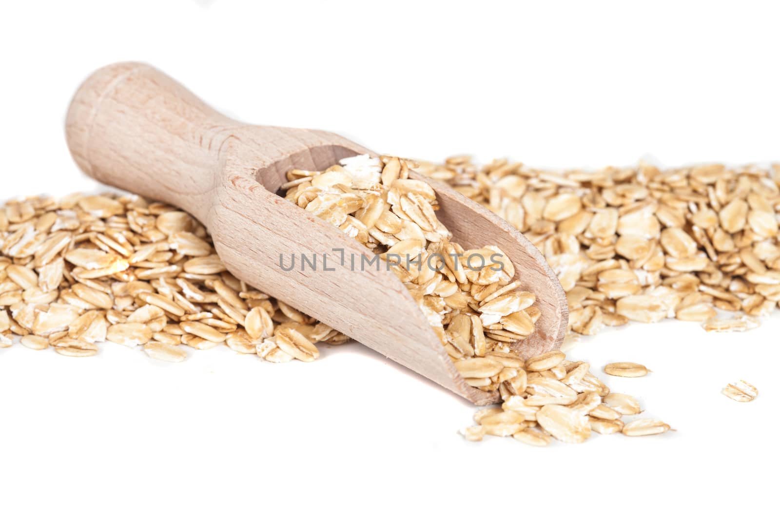 Oats flakes pile in wood spoon on white background