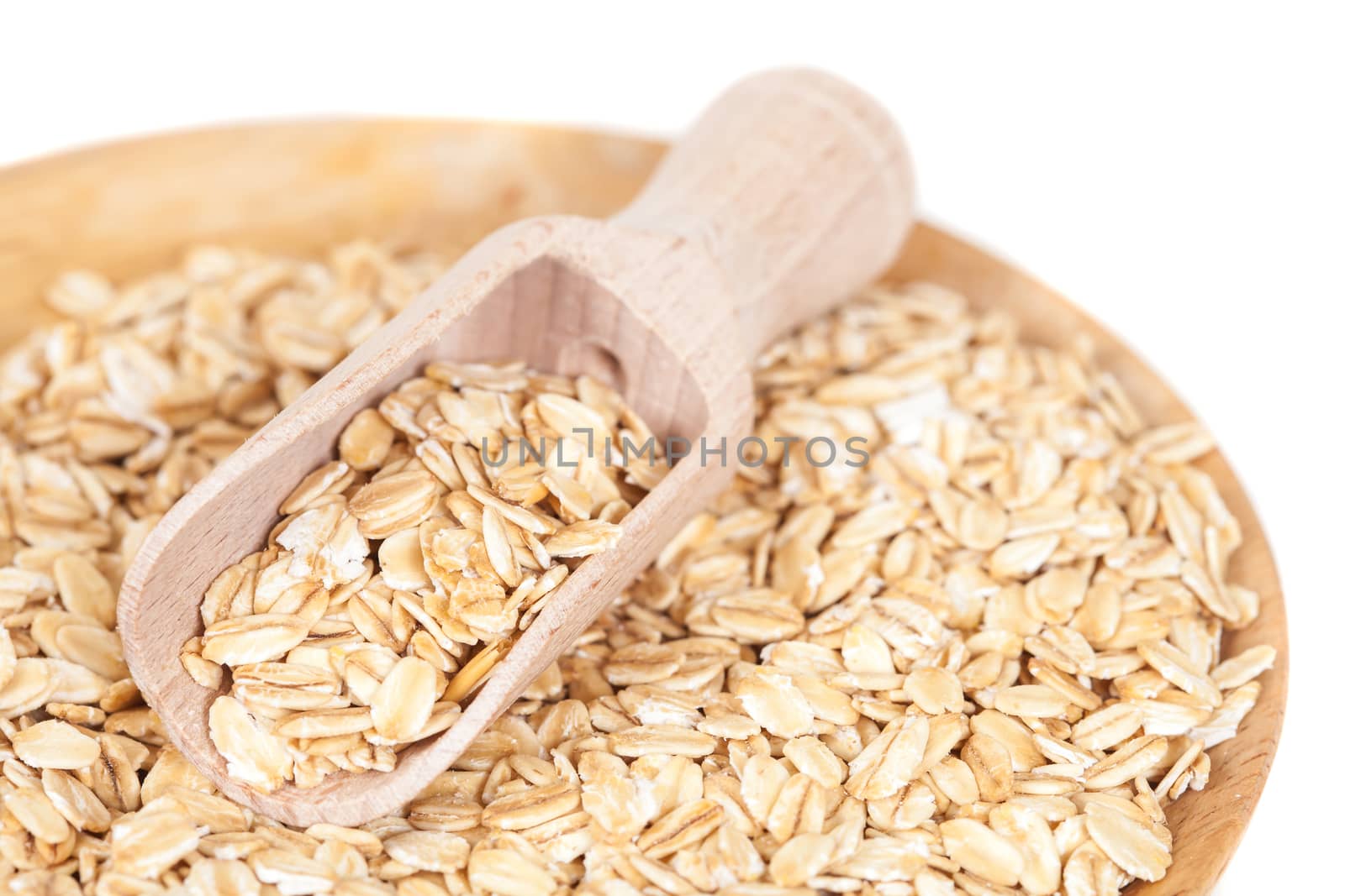 dish and wood spoon with oats flakes pile by amnarj2006