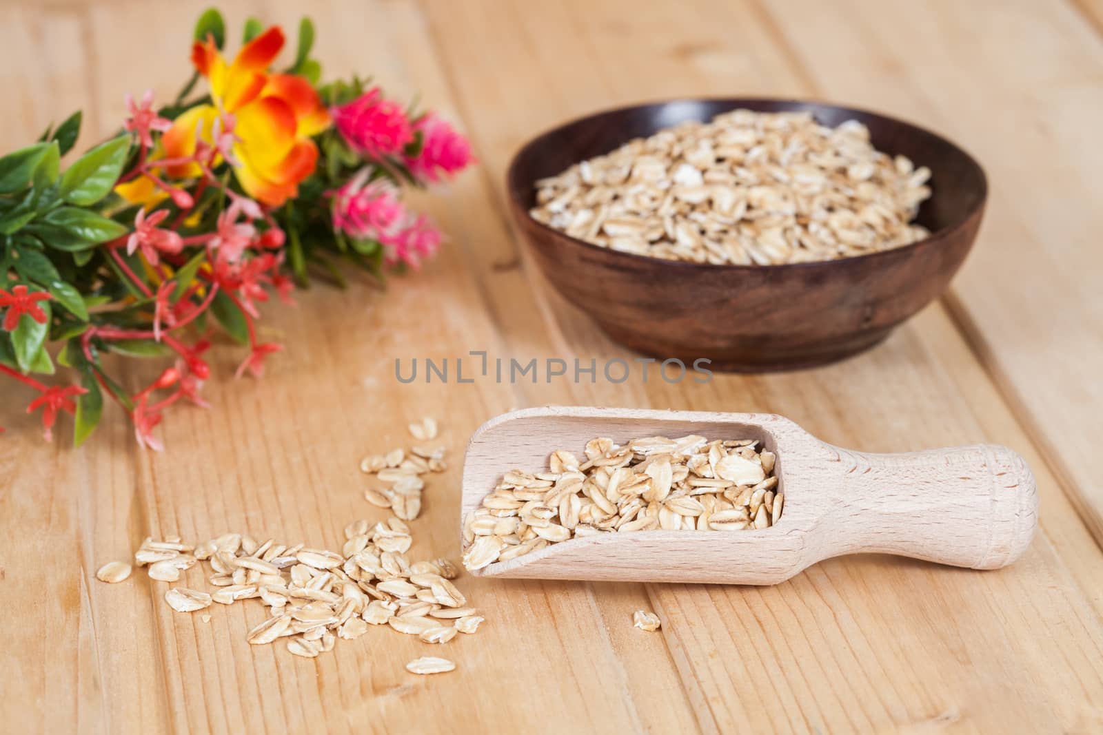 wood spoon with oats flakes pile on wood 
background.
