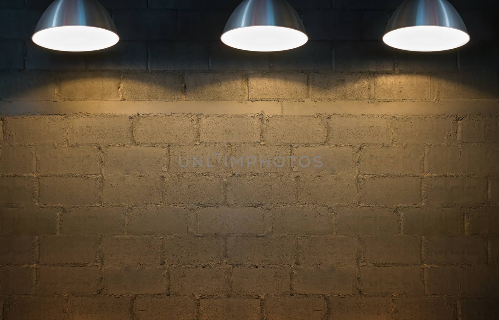 Old interior room with brick wall and three spotlights.