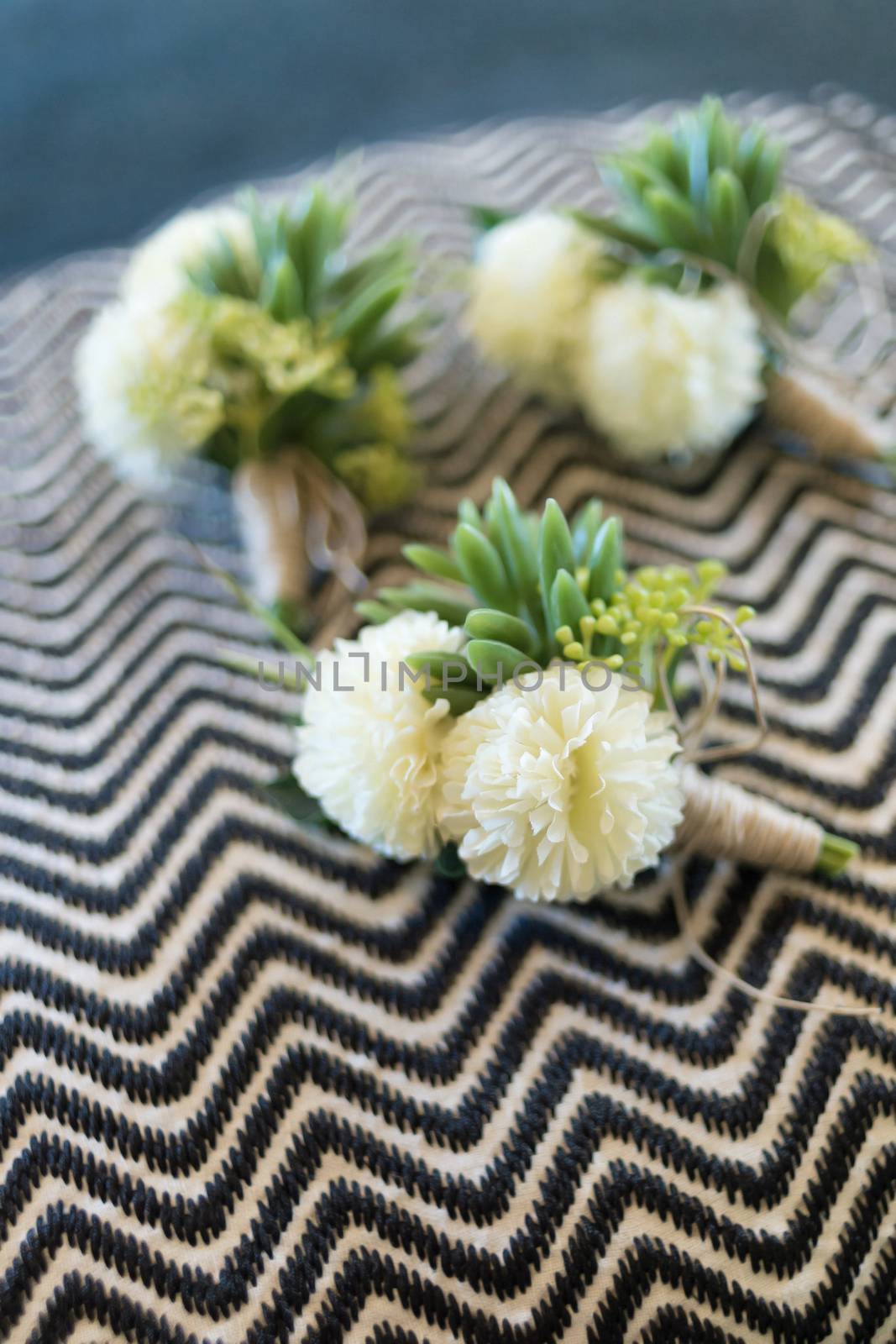 Boutonniere for groom and groomsman on black and white wavy stripes pattern fabric.