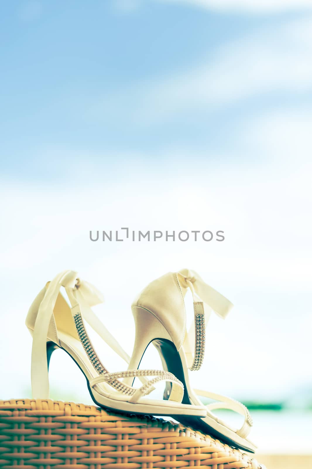 Close-up of bridal shoes with crystal necklace. Shallow depth of field. Cross process.