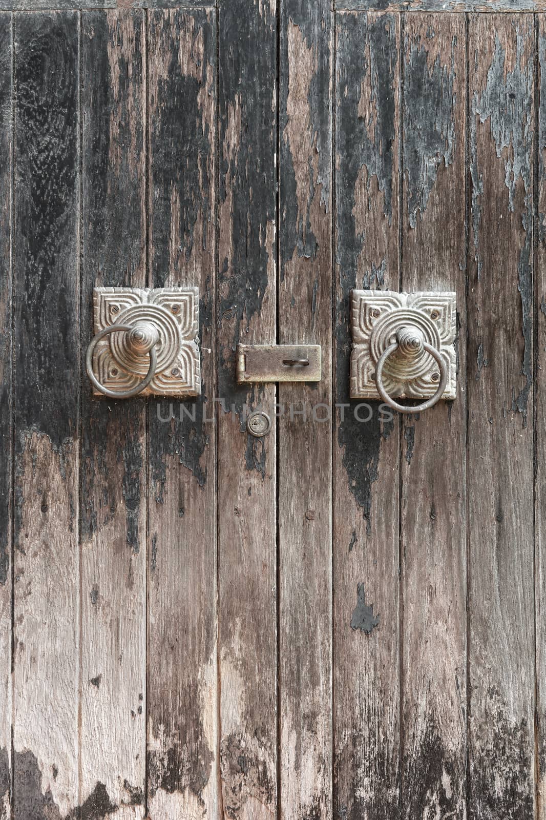 Ancient wooden gate with two door knocker rings