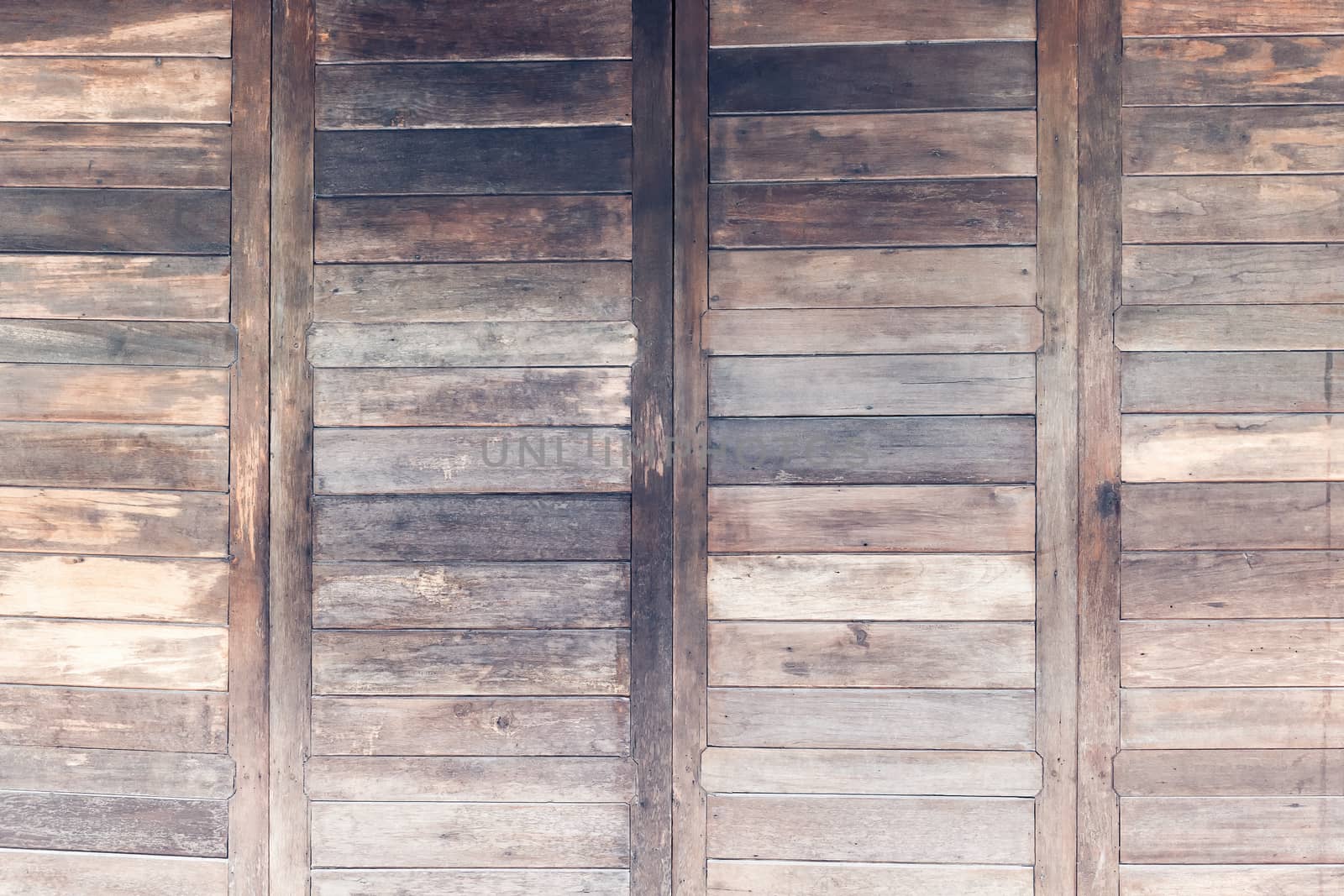 Closed wooden door in old style built. Horizontal.