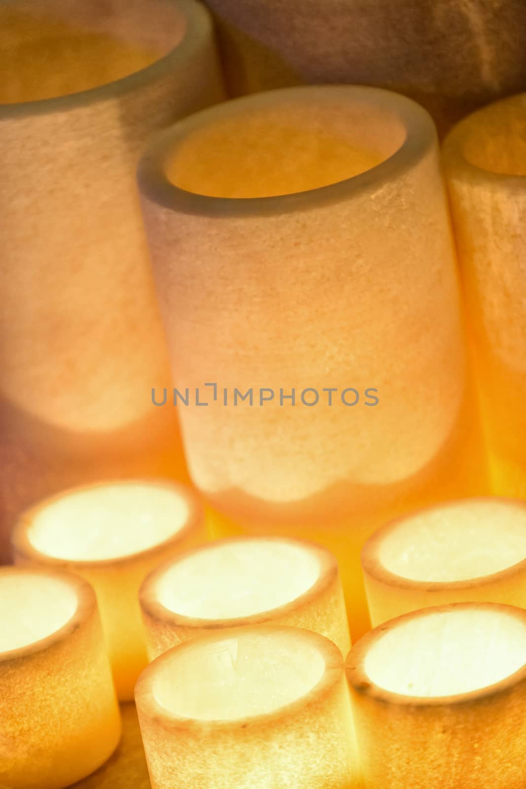 Soft focus of candlelight in cylindrical resin used in the ceremony decorations.