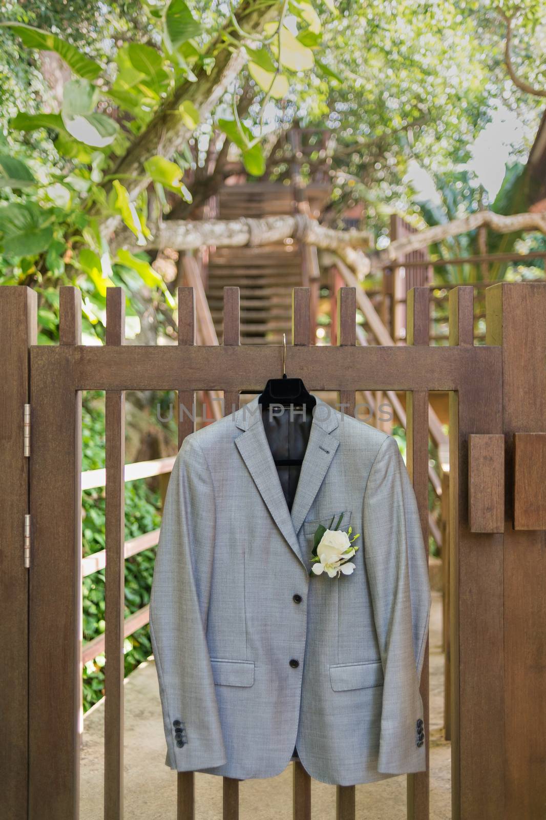 Grooms jacket hanging by fence.