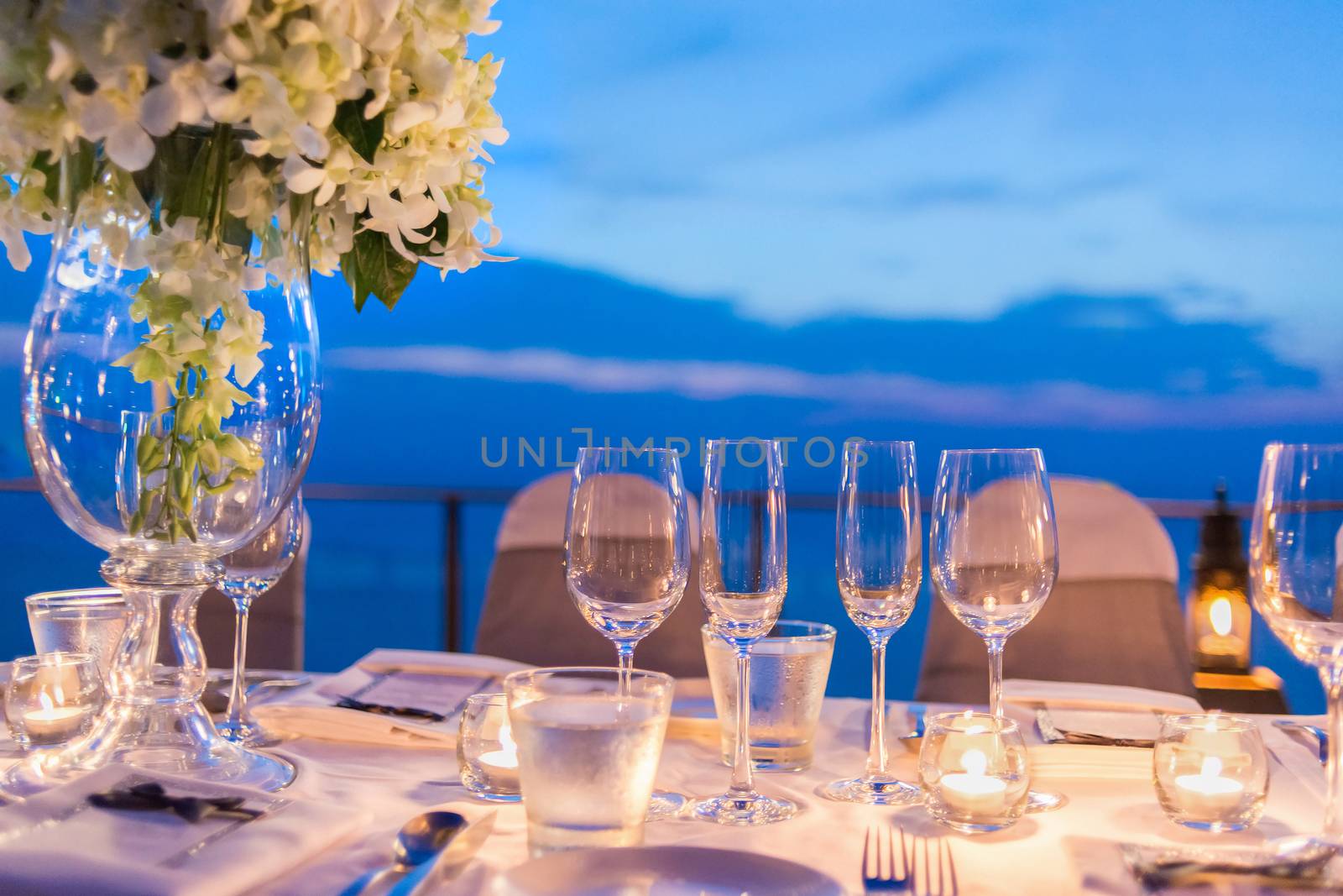 Romantic dinner setup, decoration with candle light, twightlight. Selective focus.